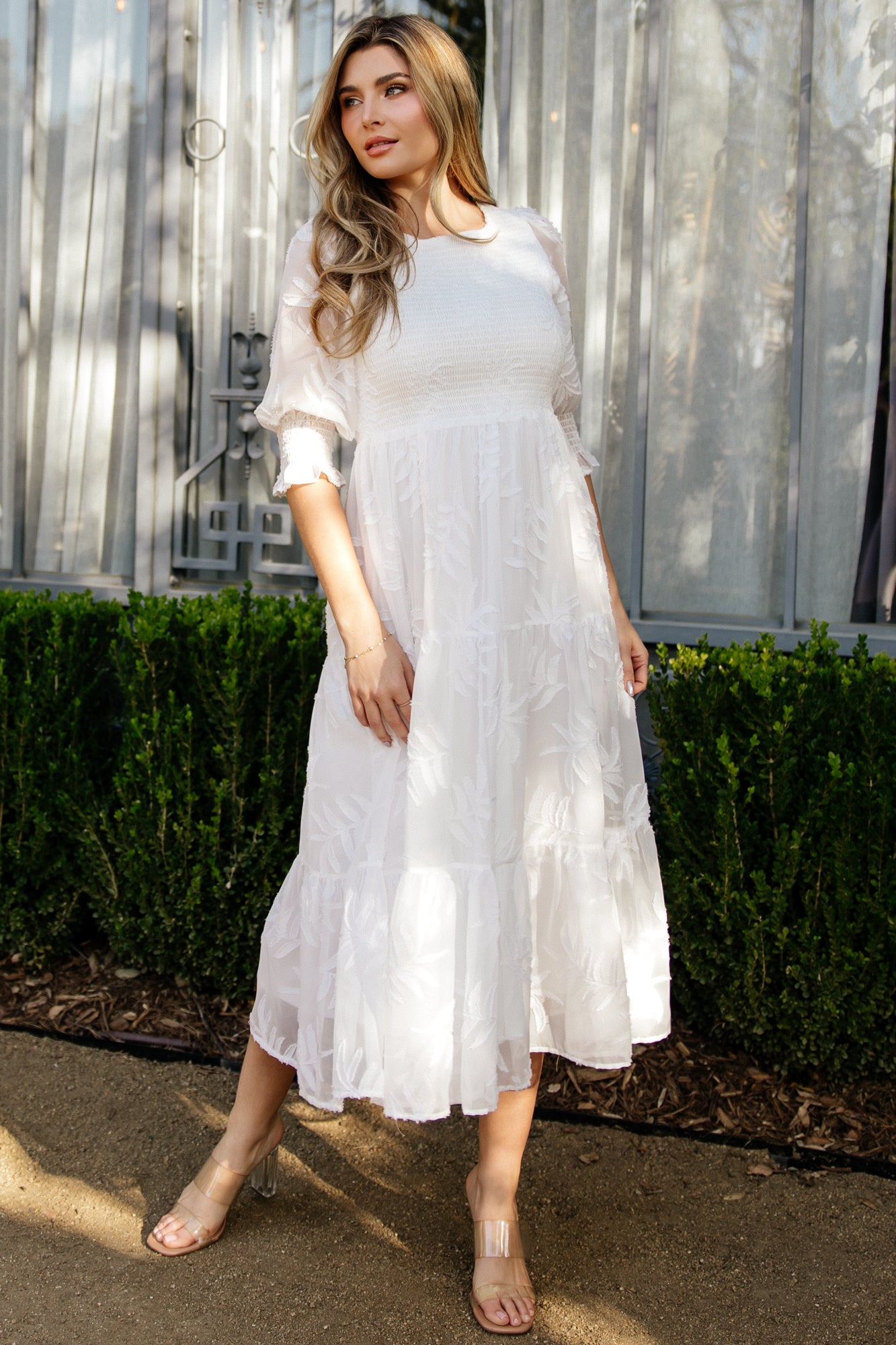 Flat-lay of off-white Nellie Smocked Midi Dress highlighting round neckline, puffed sleeves, smocked bodice and tiered skirt silhouette.
