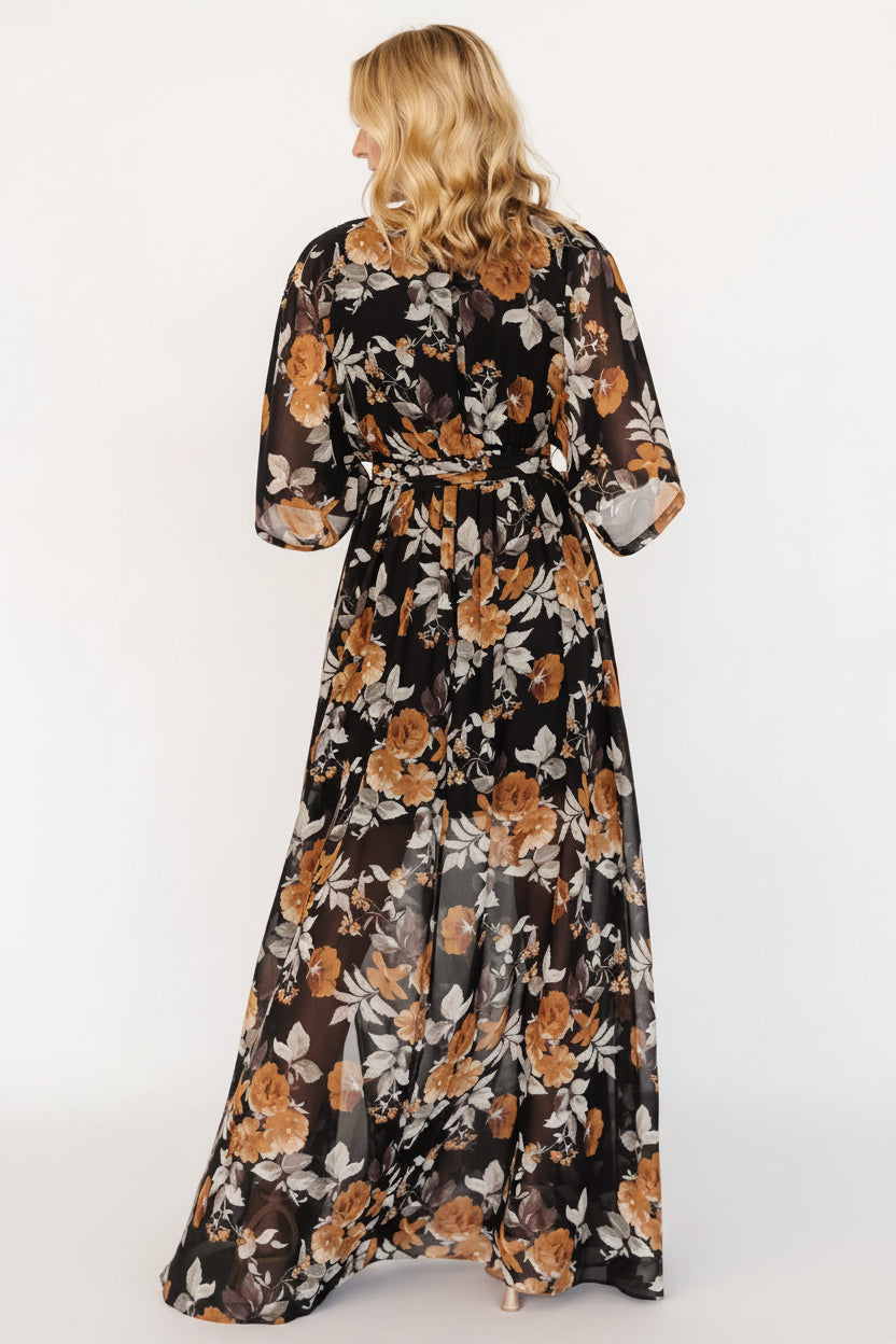 Back and hem view showing full maxi length, soft drape, and floral pattern on the Kia Kimono Maxi Dress in black and copper.