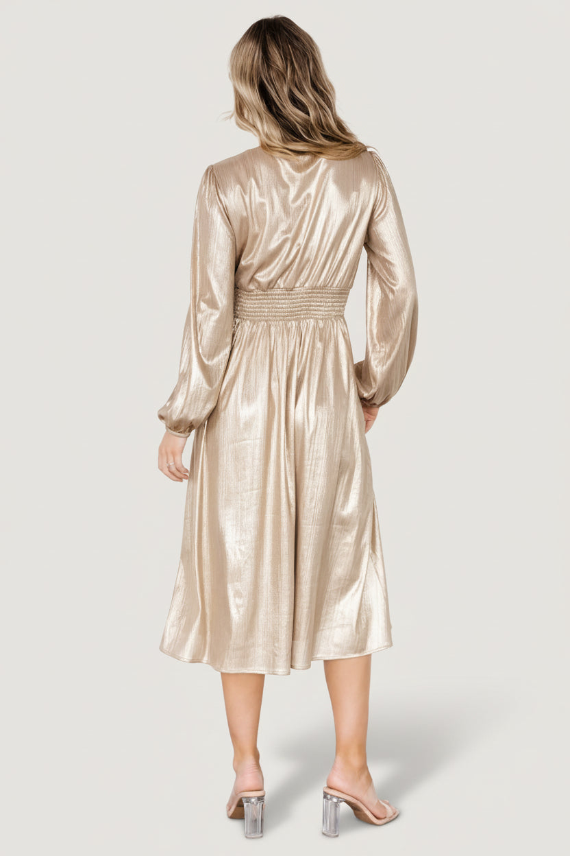 Side view of Aisha shimmer midi dress in champagne, highlighting sleeve profile, elastic cuff, gathered waistline and the dress’s graceful drape.