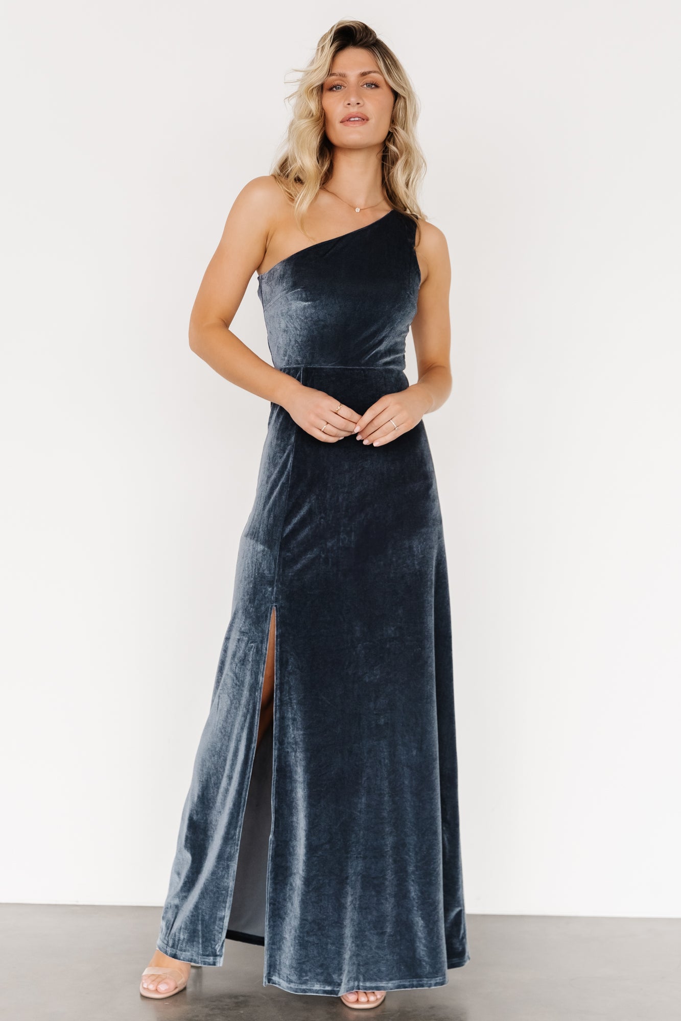 Back and drape detail of the Tatiana velvet one-shoulder maxi dress in slate blue, showing the skirt's subtle movement and lining.