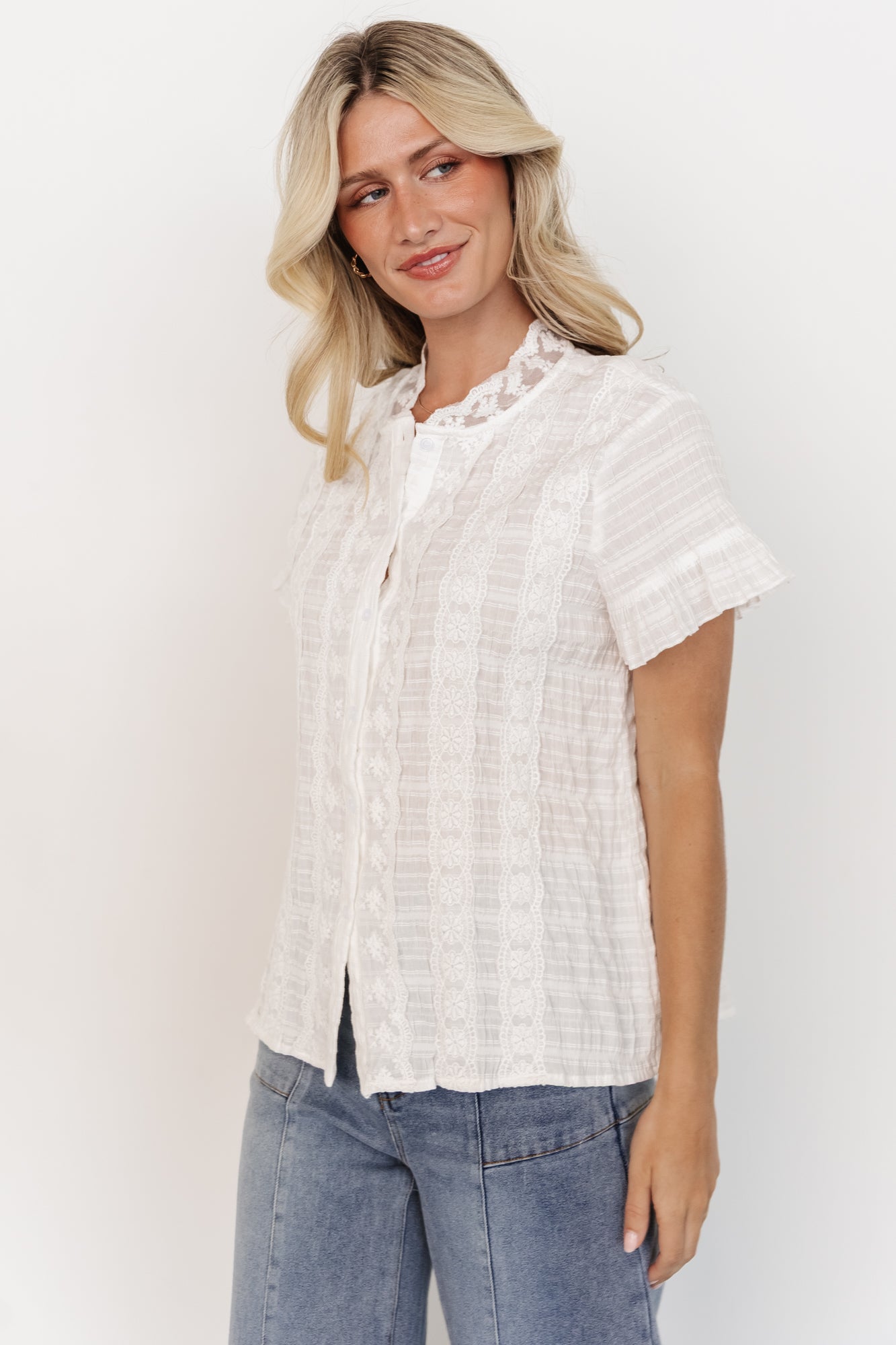 Detail shot of the Zara Lace Top sleeve and hem emphasizing the short ruffle sleeve, stitch detail, and textured cotton material.