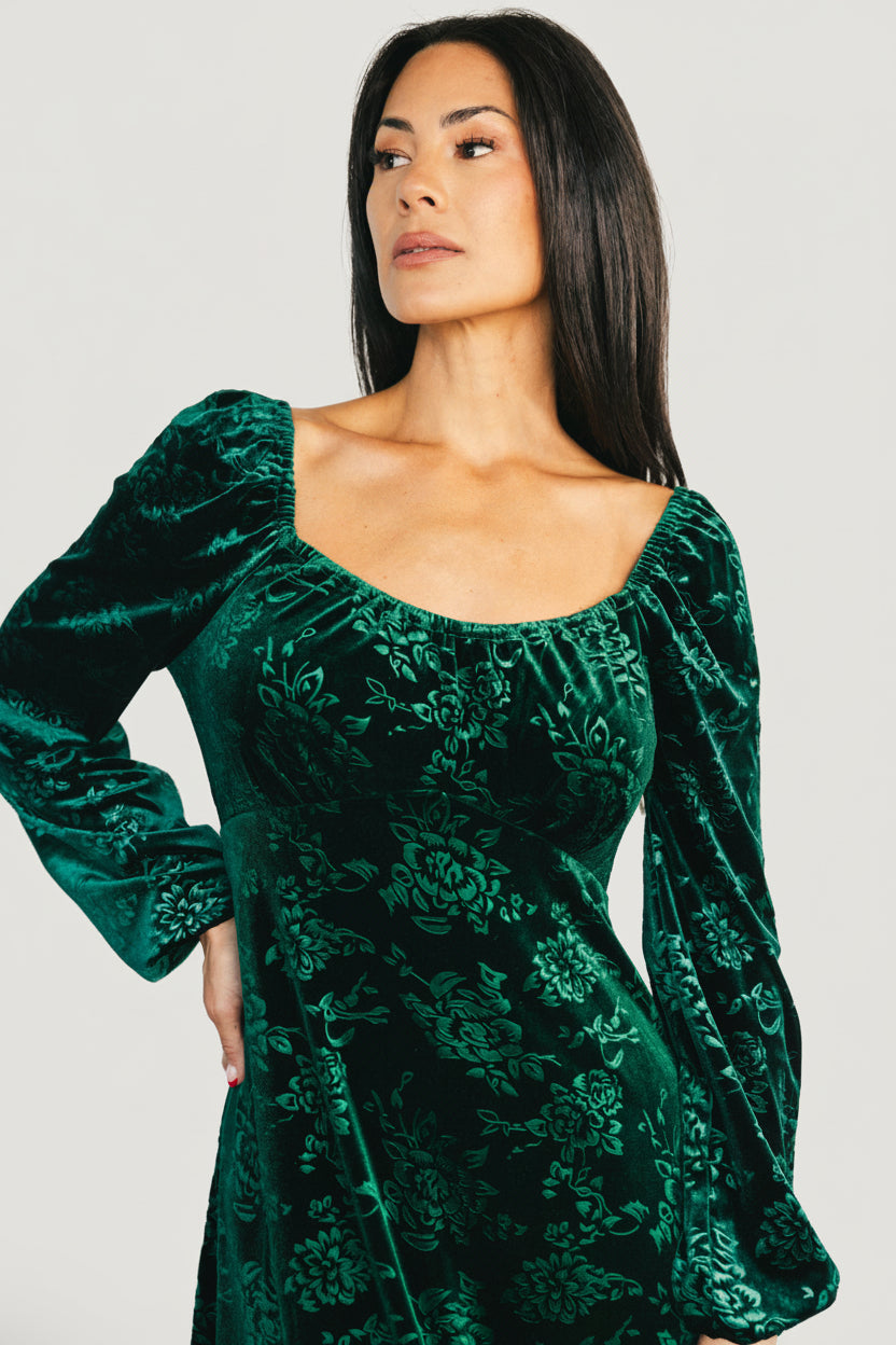Close-up of embossed velvet floral pattern on the Audra dress showing dimensional burnt-out texture and rich emerald color.