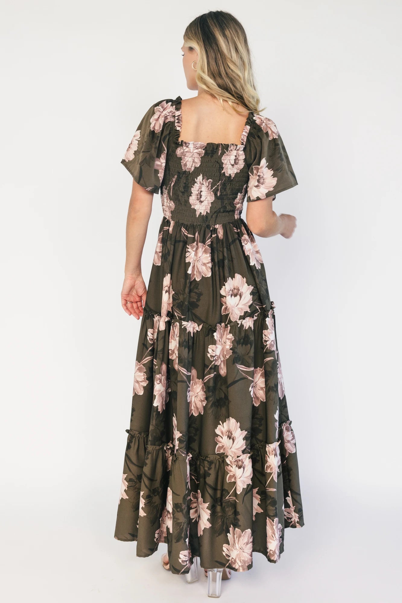 Dark olive floral maxi dress with a smocked bodice, square neckline, flutter sleeves, and a tiered ruffle skirt.