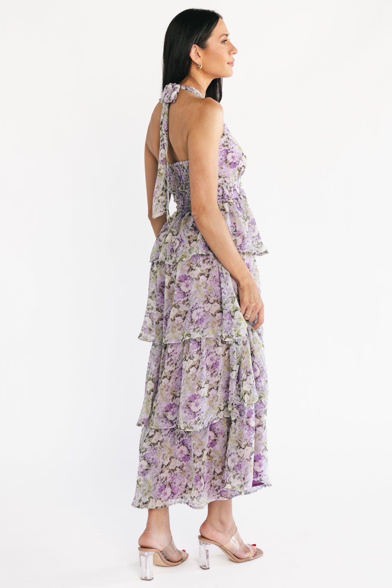 Side view close-up of lavender floral halter dress displaying left side invisible zipper, fitted waist and flowing tiered ruffles.