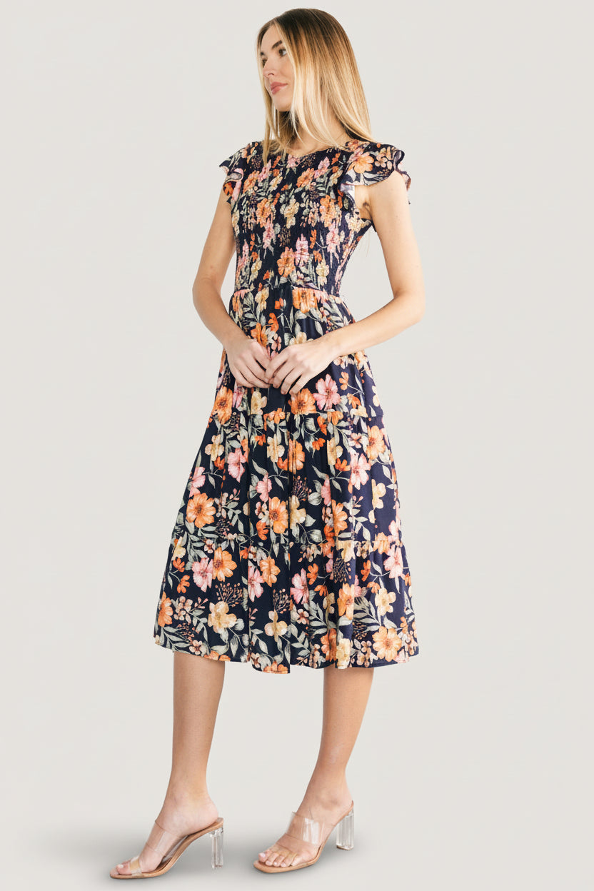Detail image focusing on the woven crepe fabric and floral print of the Loretta midi dress, emphasizing texture and color depth.