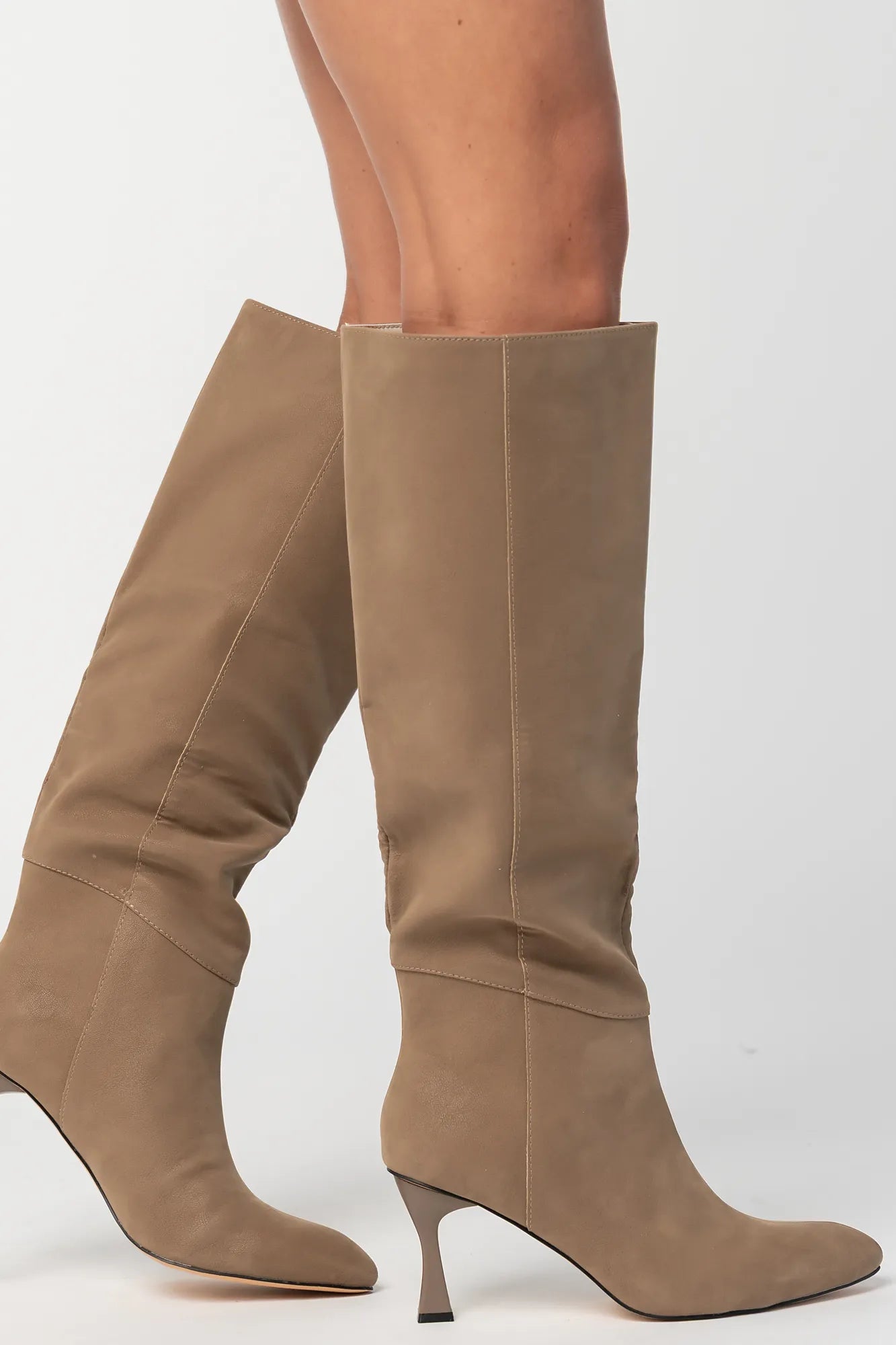 Pair of mocha knee-high boots featuring a pointed toe, sleek fitted shaft, and sculpted kitten heel. The streamlined silhouette and smooth finish create an elegant, versatile look that pairs effortlessly with dresses, skirts, and tailored outfits.