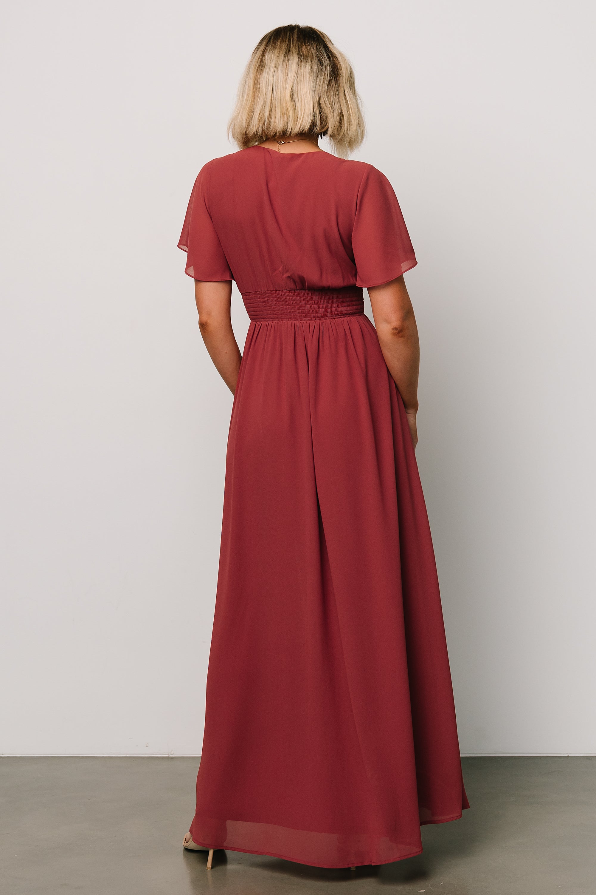 Detail image of short flutter sleeves and V-neckline on the terracotta Ramona chiffon maxi dress.
