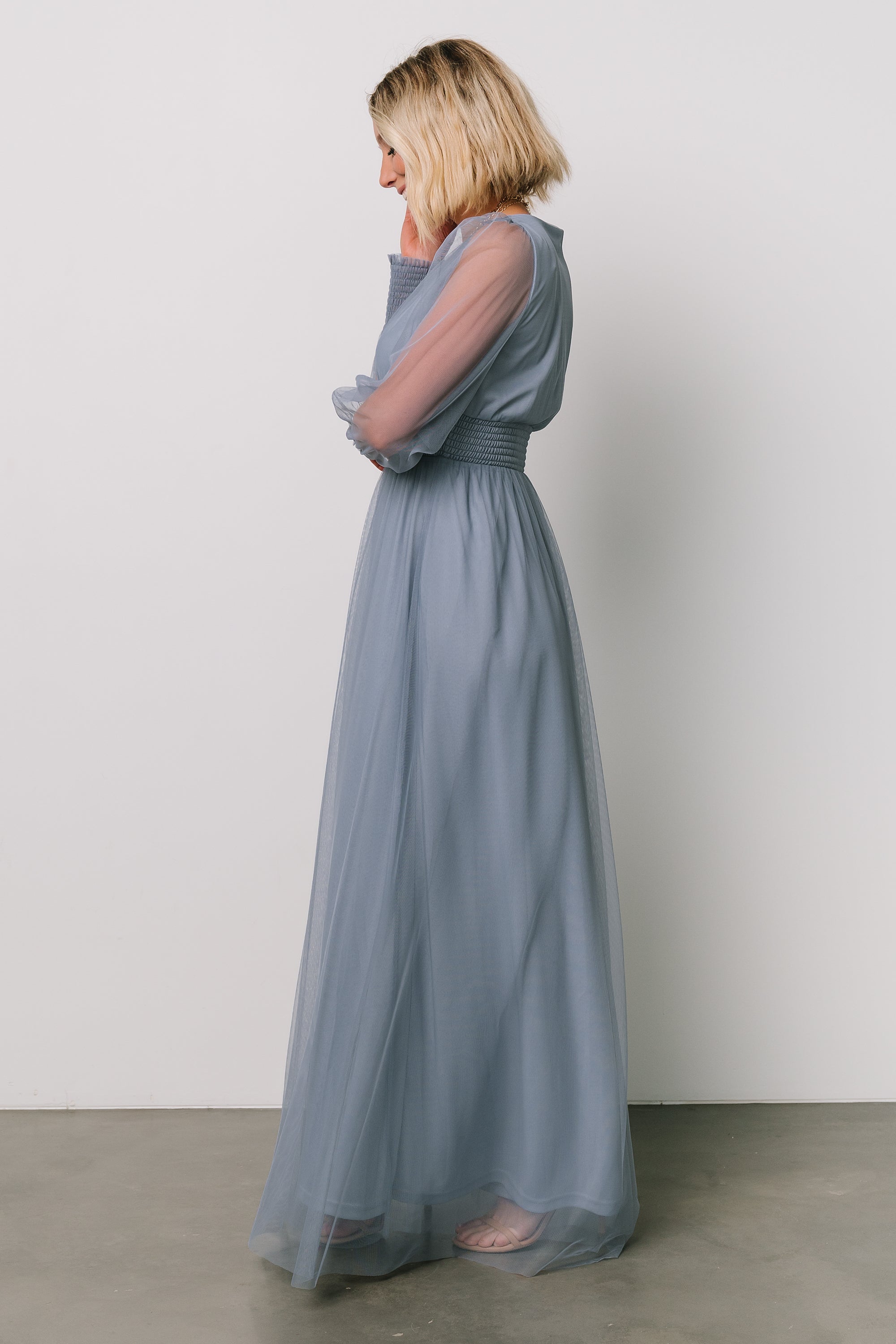 Model wearing Layla Tulle Maxi Dress in whisper blue walking pose that emphasizes the dress’s lightweight tulle movement and full-length maxi silhouette.