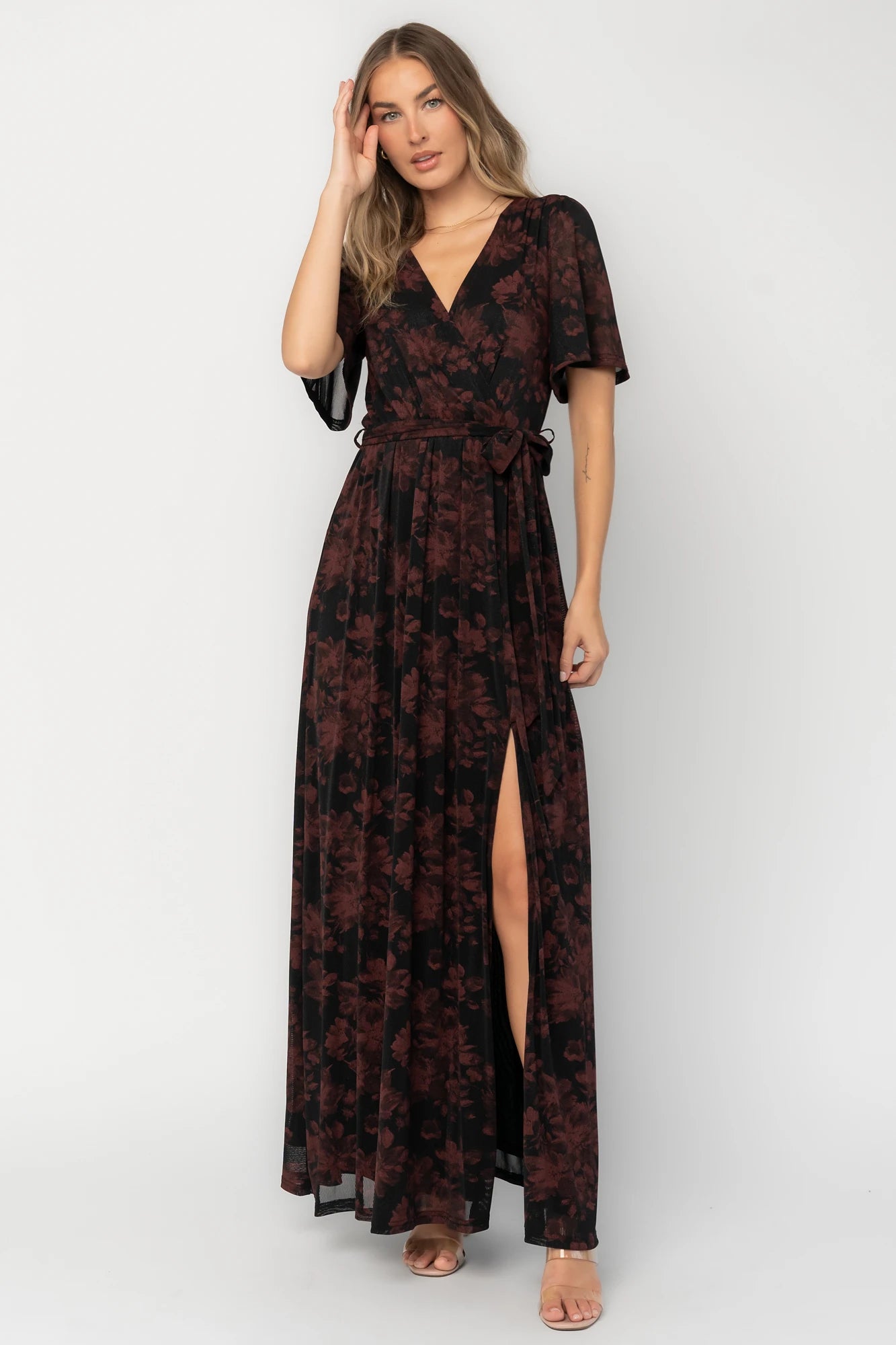 Black and burgundy floral shimmer maxi dress with flutter sleeves, surplice V-neck, elastic waist, removable sash, and side leg slit.