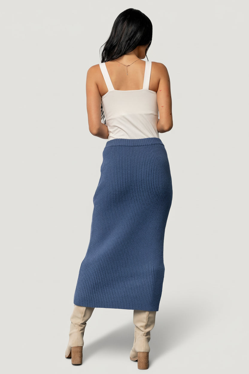 Flat lay of the blue rib knit midi skirt displaying the overall rib pattern, raw hem edge, and the gently elastic waistband for easy wear.