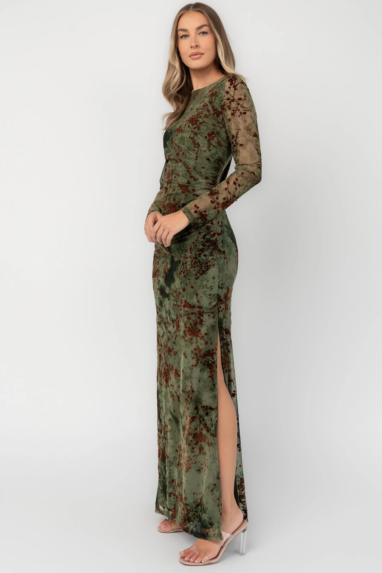 Green and rust floral mesh maxi dress with sheer long sleeves, boat neckline, and fitted silhouette.