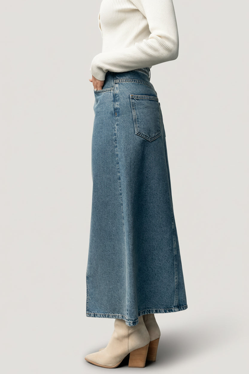 Back view of medium wash denim Aleksa midi skirt showing functional back pockets, yoke detail, and mustard contrast stitching.