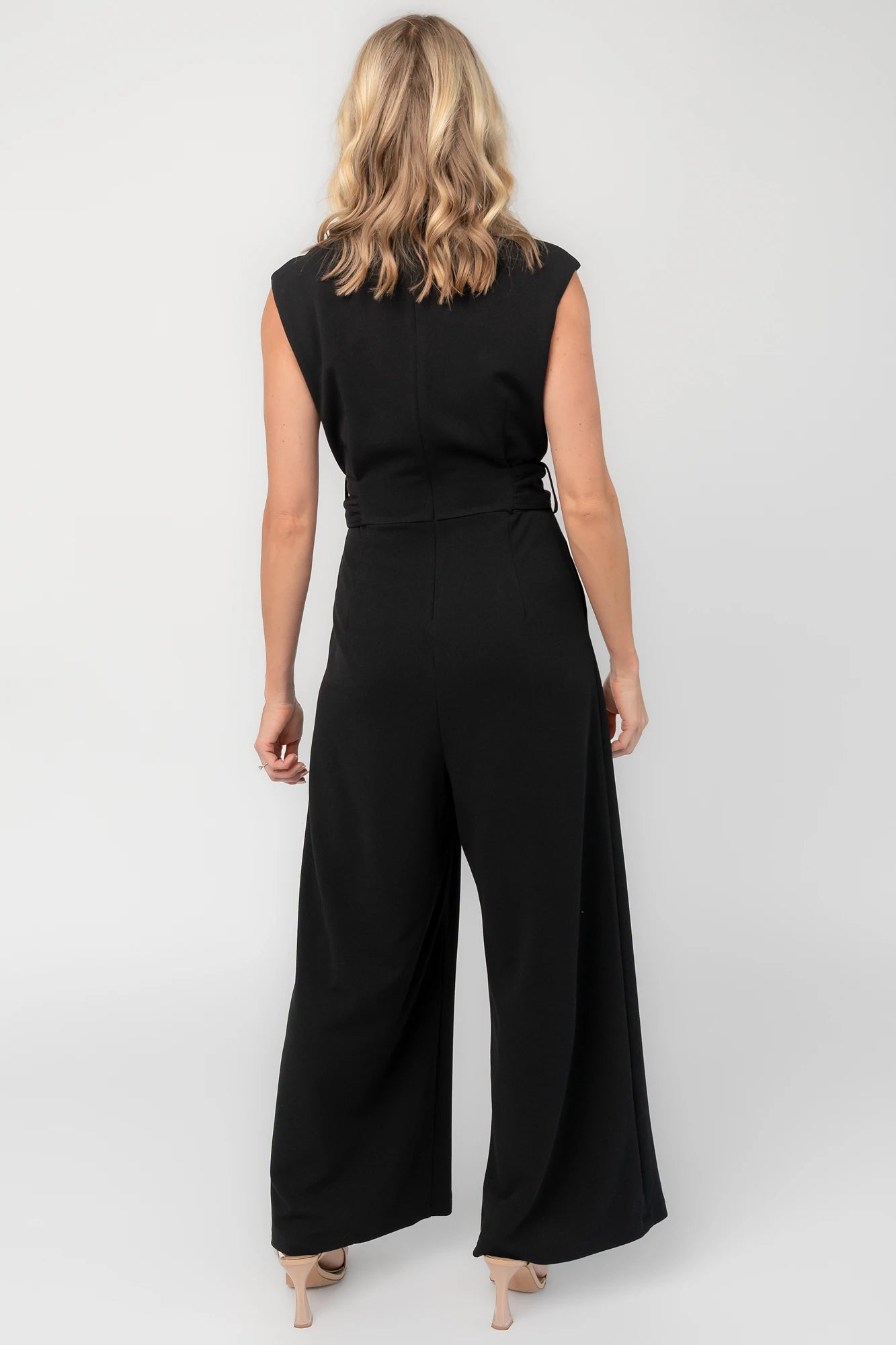 Black tailored wide-leg jumpsuit with a mock neckline, cap sleeves, removable tortoise buckle belt, and side pockets.
