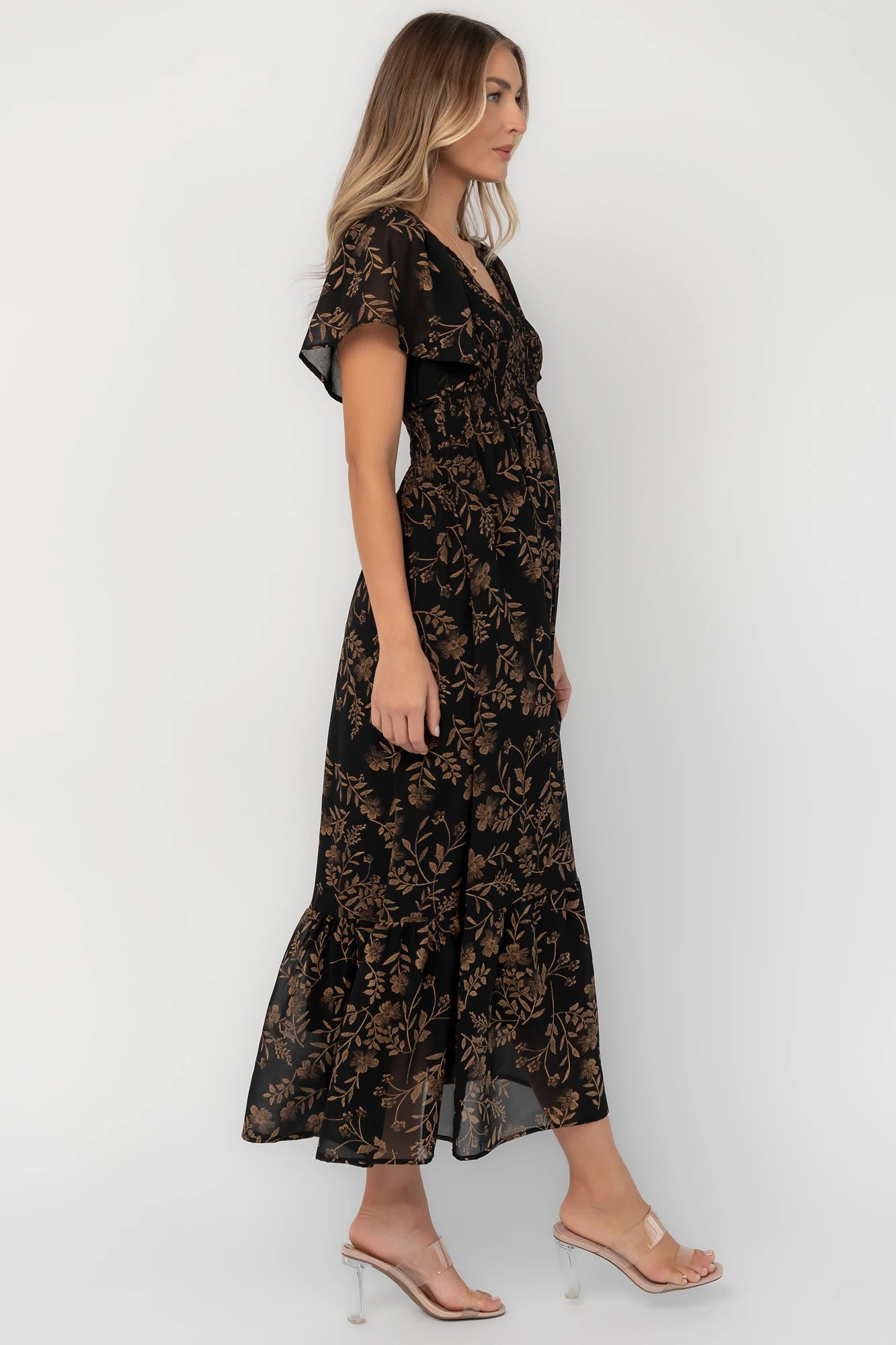 Black and gold chiffon maxi dress with a V-neckline, flutter sleeves, smocked bodice, empire waist, tiered skirt, and side pockets.