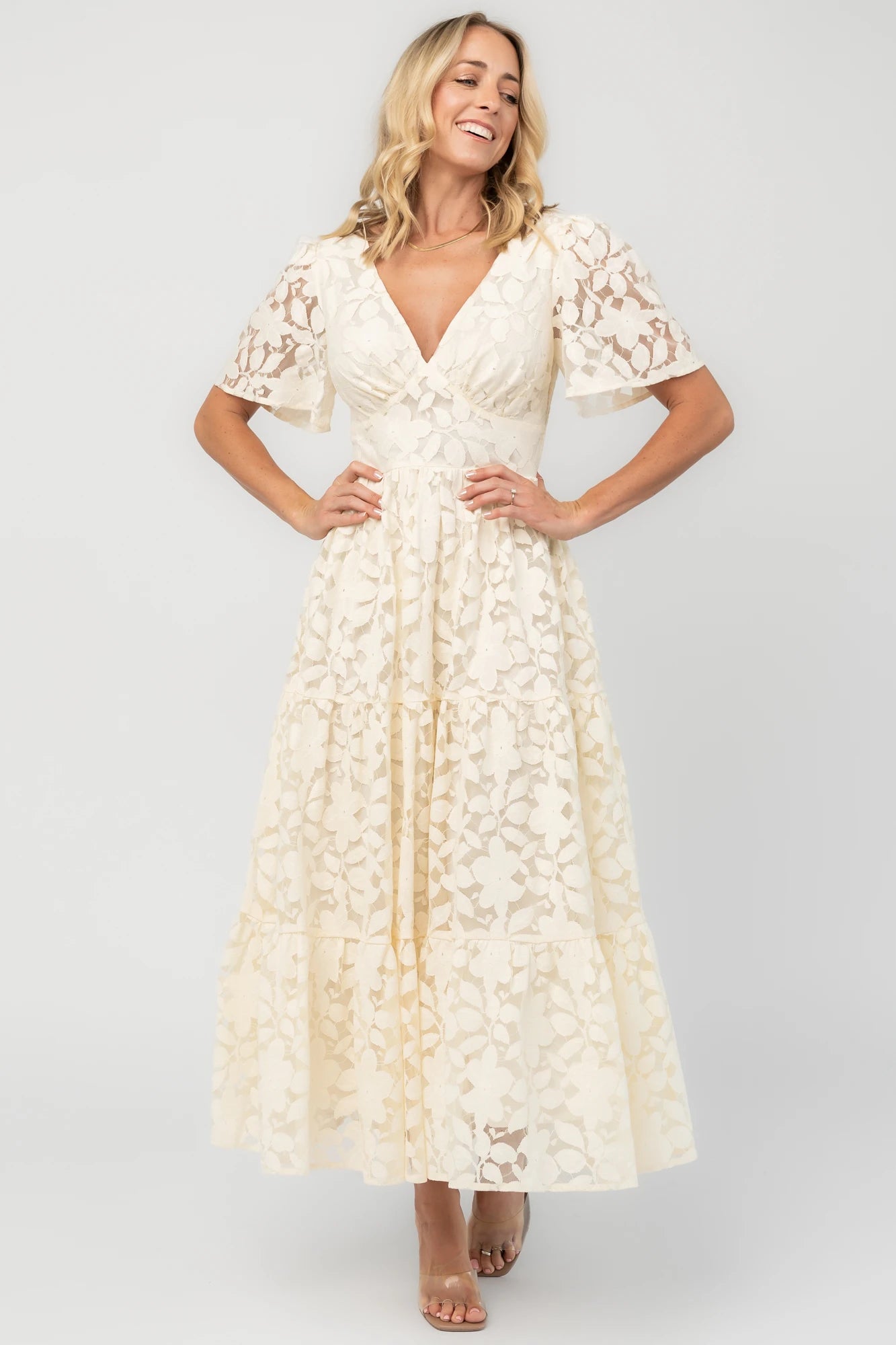 Floral lace midi dress with a deep V-neckline, short flutter sleeves, smocked back bodice, defined waistband, and tiered skirt.