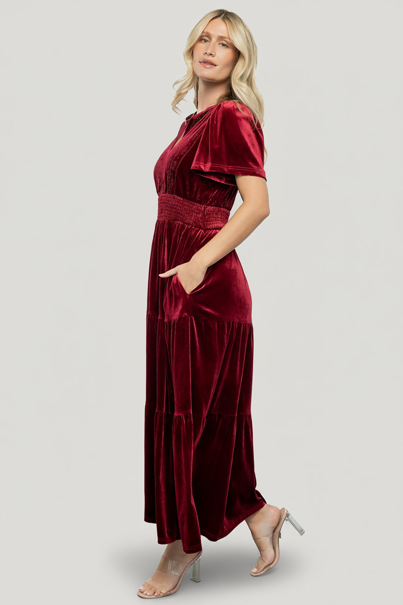 Styled look of Maida embroidered velvet dress paired with accessories, showing V-neck collar, embroidery, smocked waist and maxi length.