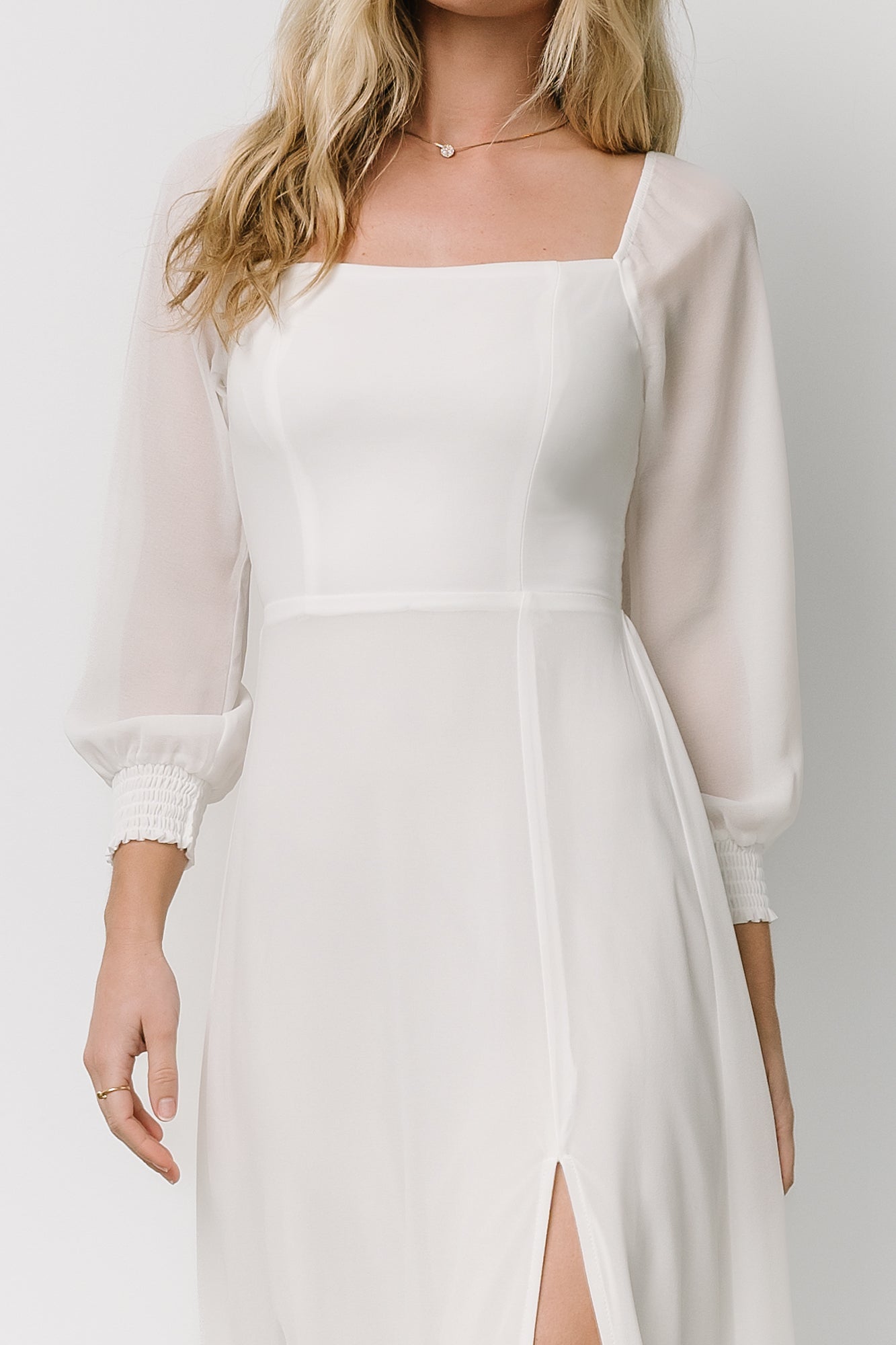 Three-quarter sleeve detail showing smocked cuffs and lightweight chiffon fabric in the white Giselle maxi dress.