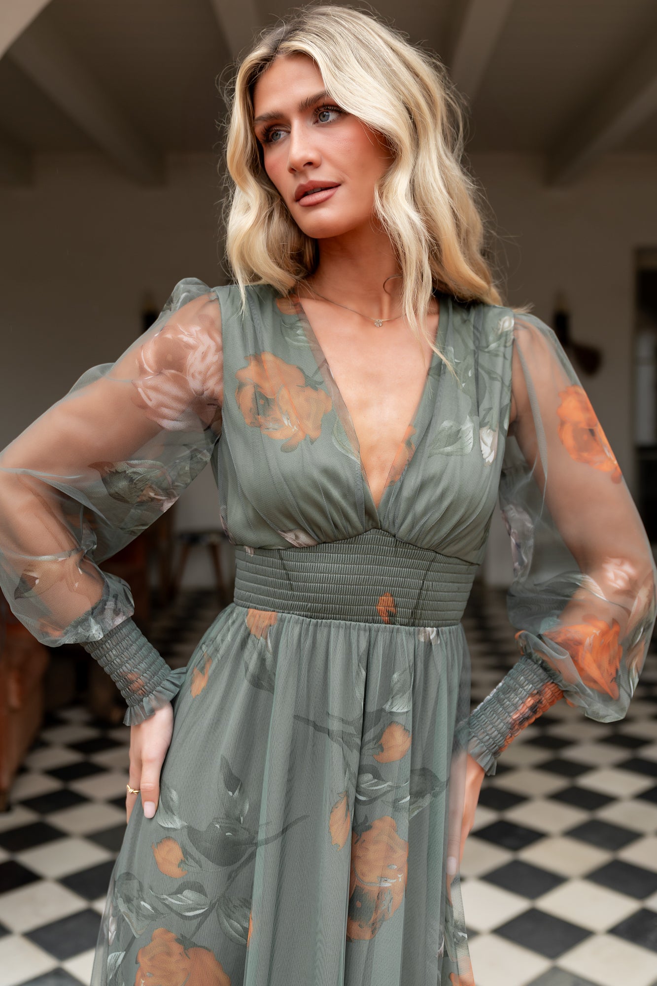 Side-angle of Layla Tulle Maxi Dress in dusty olive floral, showing long sleeves with smocked cuffs and the dress's layered, airy tulle movement.