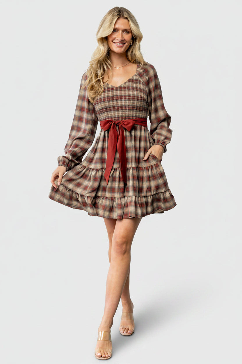 Back view of Stina Short Dress showing elastic waistline, smocked back detail, and the plaid pattern across the skirt panels.
