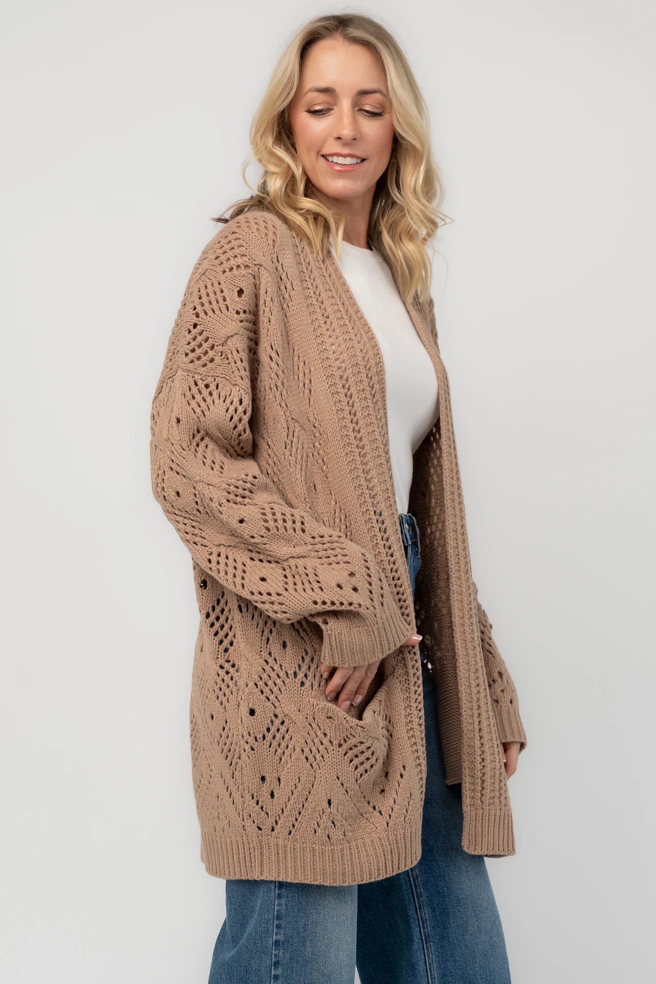 Light mocha open-front pointelle knit cardigan with long balloon sleeves, front patch pockets, ribbed trim, and a relaxed oversized silhouette.
