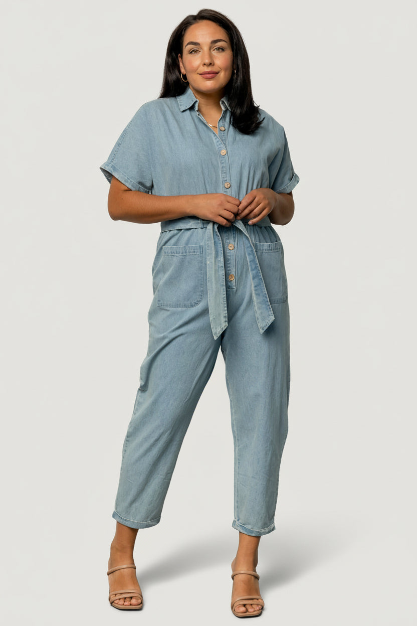 Close-up of front button-up placket and shirt collar on Mateo denim jumpsuit, showing button detail and fabric texture.