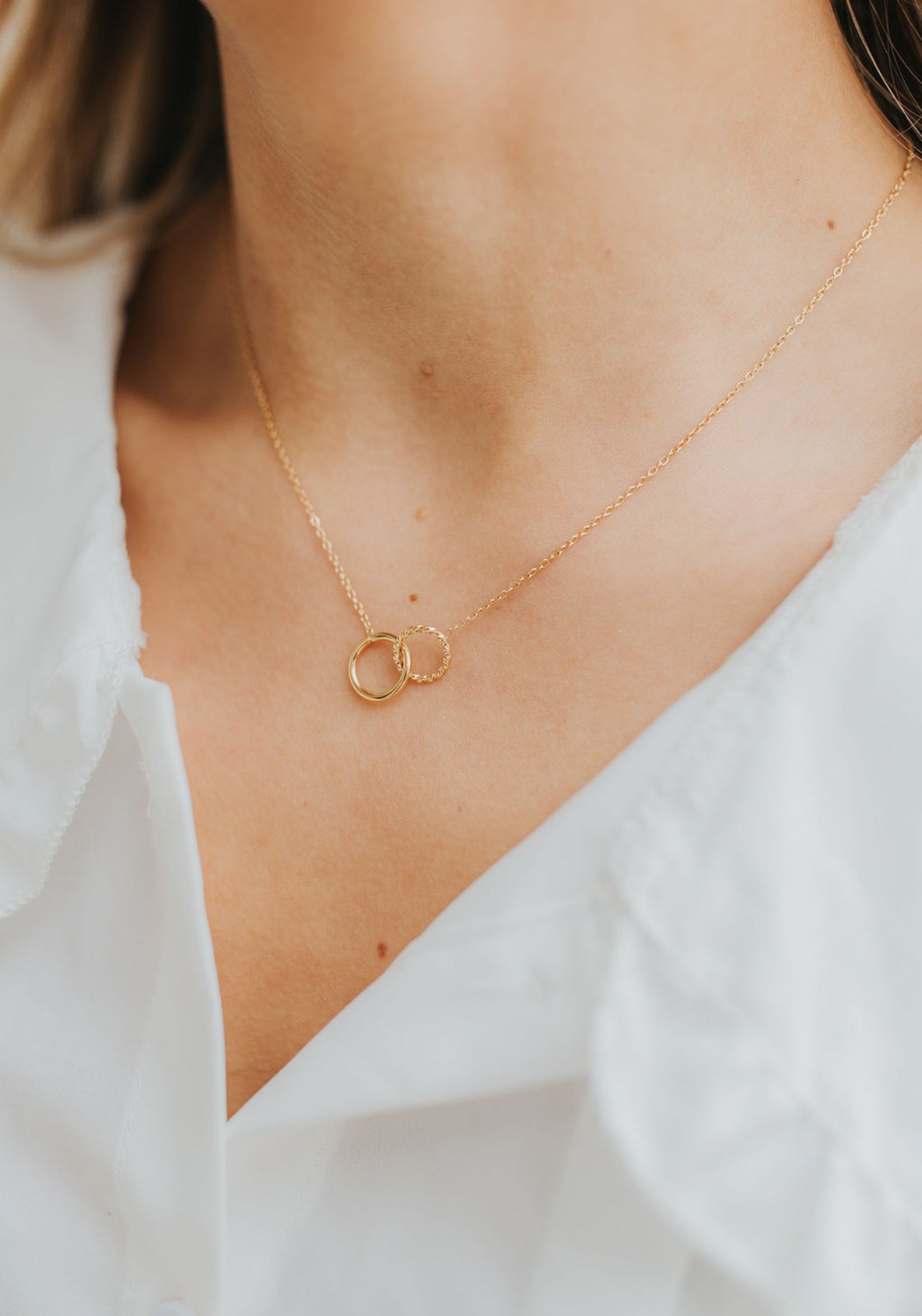 Lifestyle image of The Mia Necklace worn at the collarbone, showing scale, finish, and layered styling possibilities.