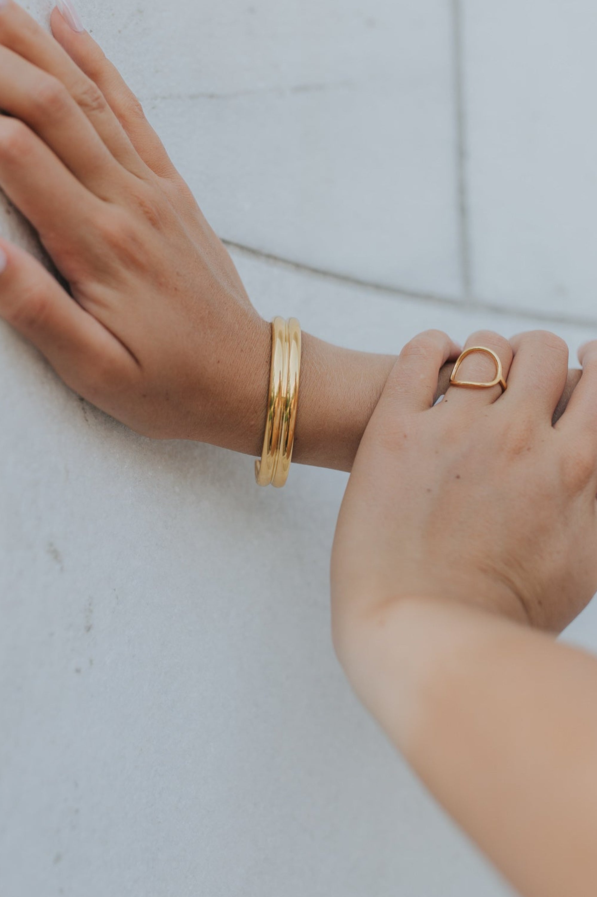 Close-up detail of dual-bar cuff edge and polished surface emphasizing the gold plating and precise construction.