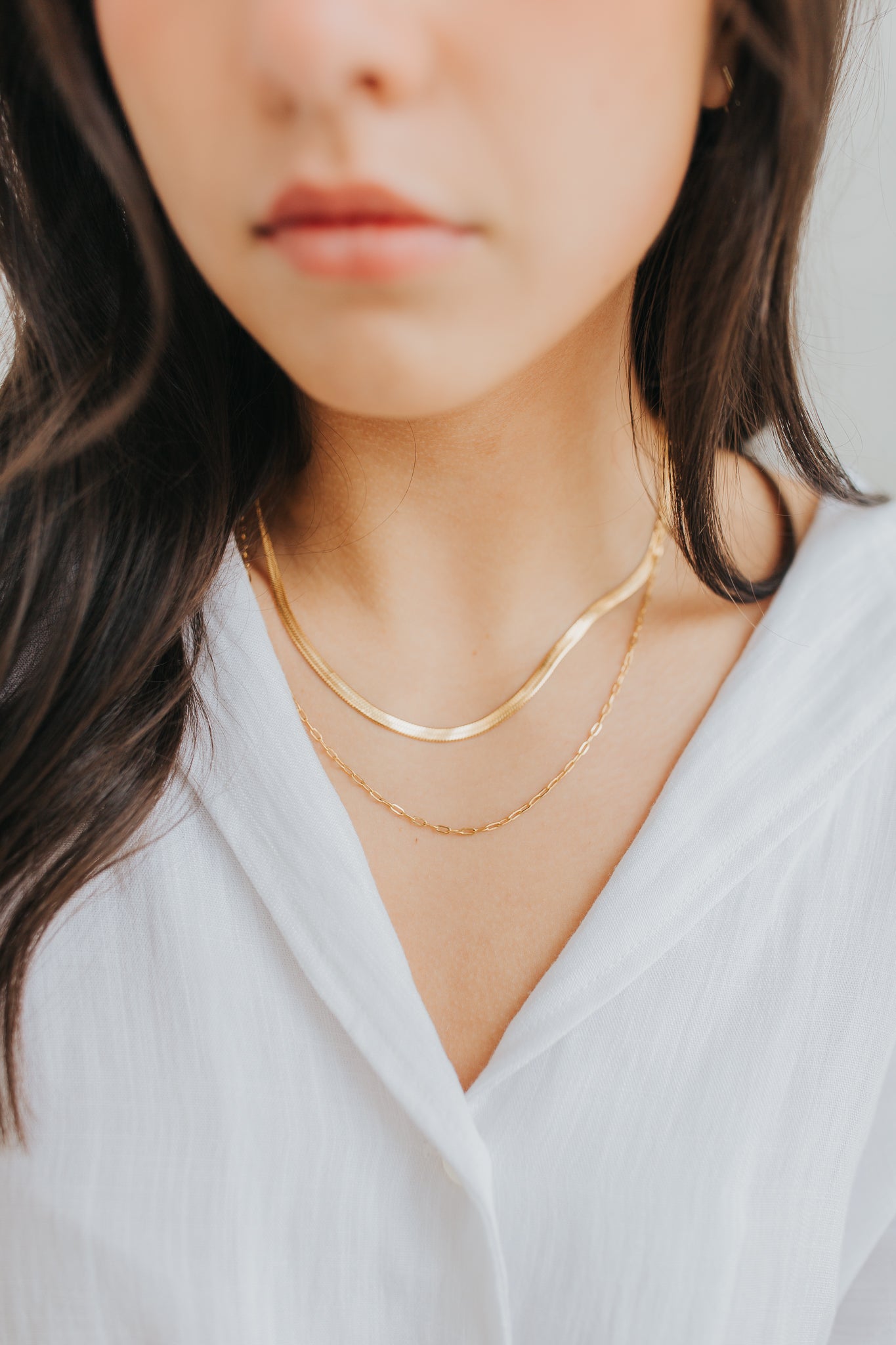 Model wearing the Christina double-chain necklace in gold at the collarbone, illustrating layered look and subtle shine with minimalist styling.