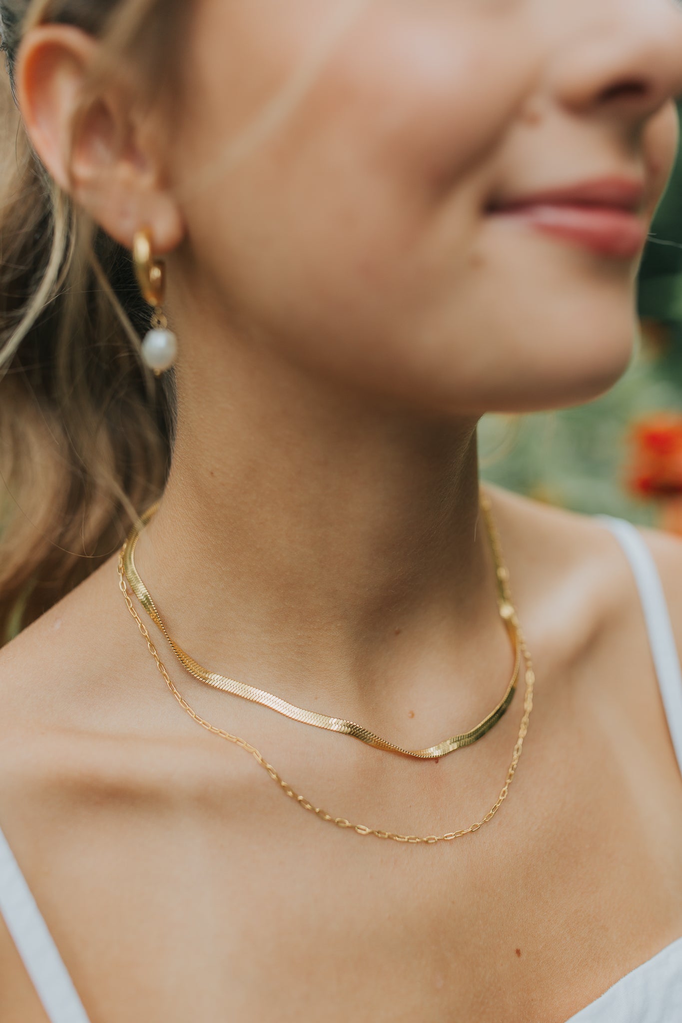 Macro view of the chain links and plated finish on the Christina necklace, showing texture, shine, and corrosion-resistant titanium base.