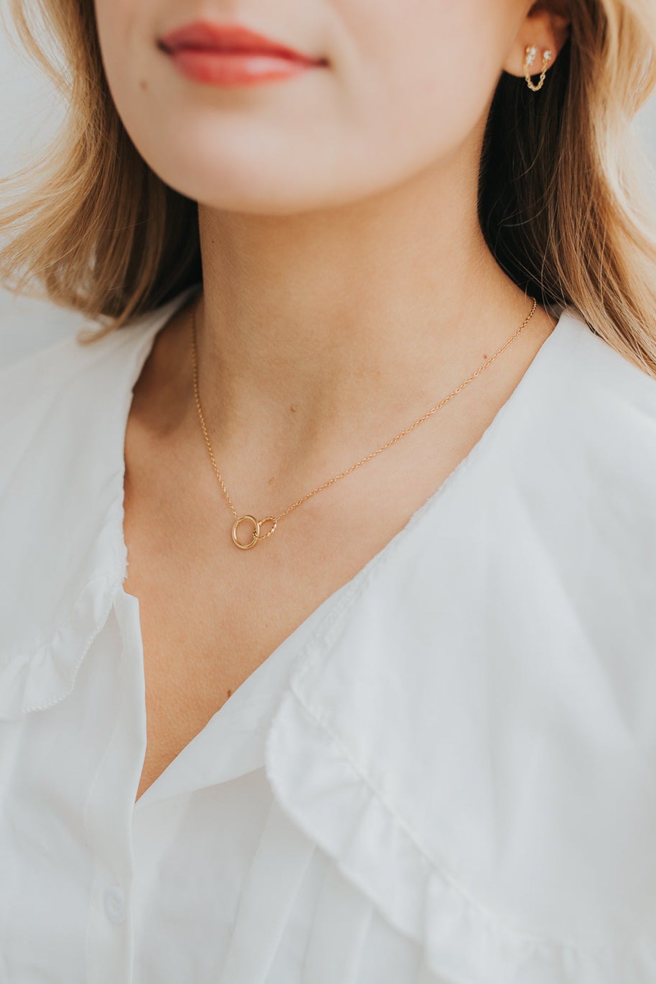 Studio shot of The Mia Necklace on a neutral background, focusing on the textured circle and delicate chain details.