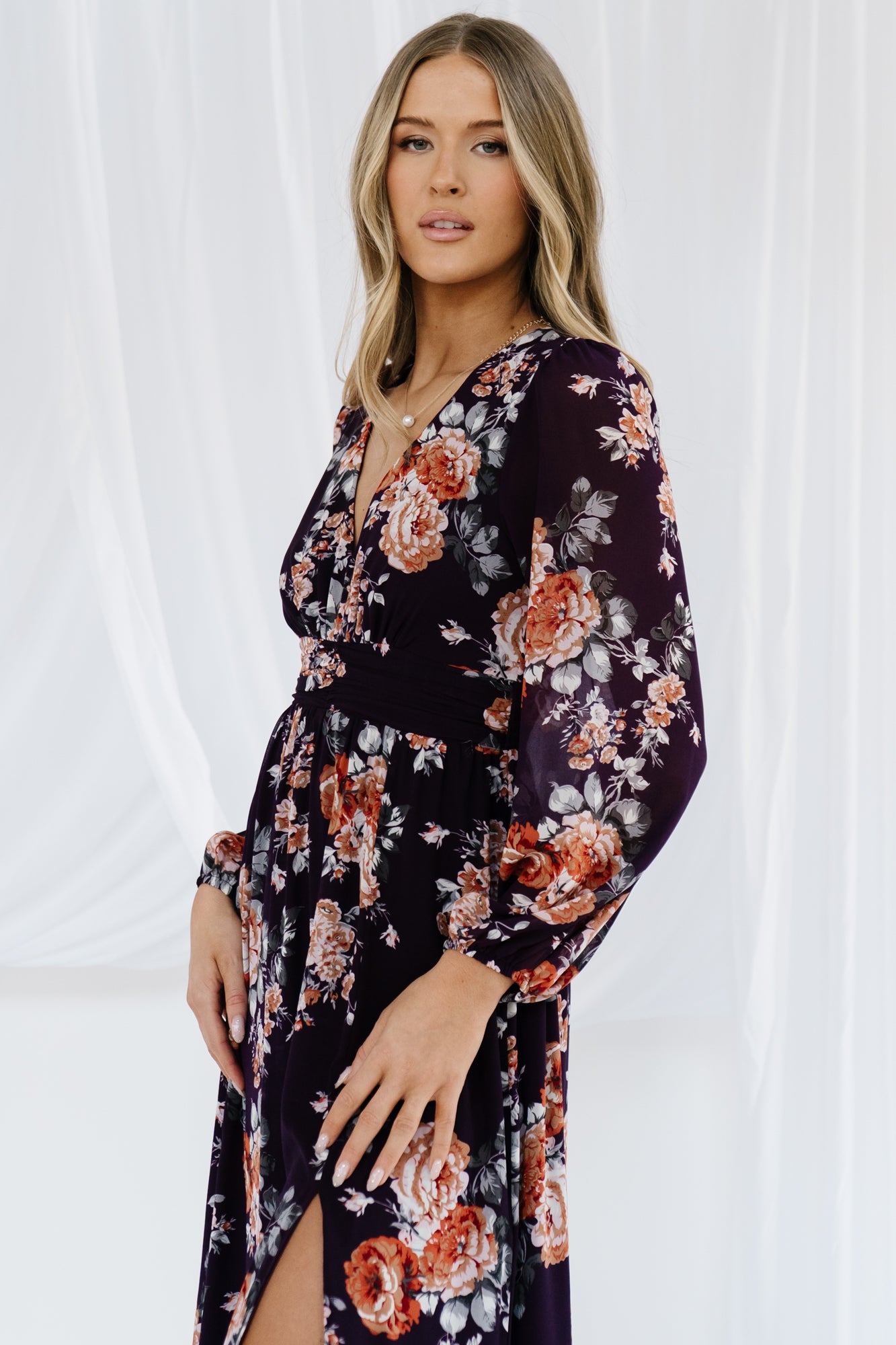 Detail image of long airy bishop sleeve with elastic cuff on plum floral Adira dress, highlighting soft volume and sleeve construction.
