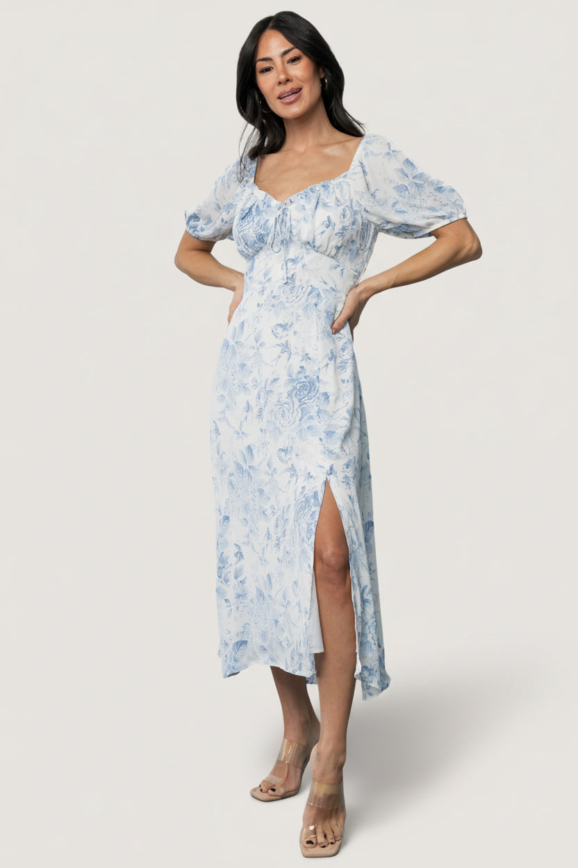 Lifestyle view of the blue floral Cadence Midi Dress outdoors emphasizing print scale, soft drape, and flowy A-line skirt.