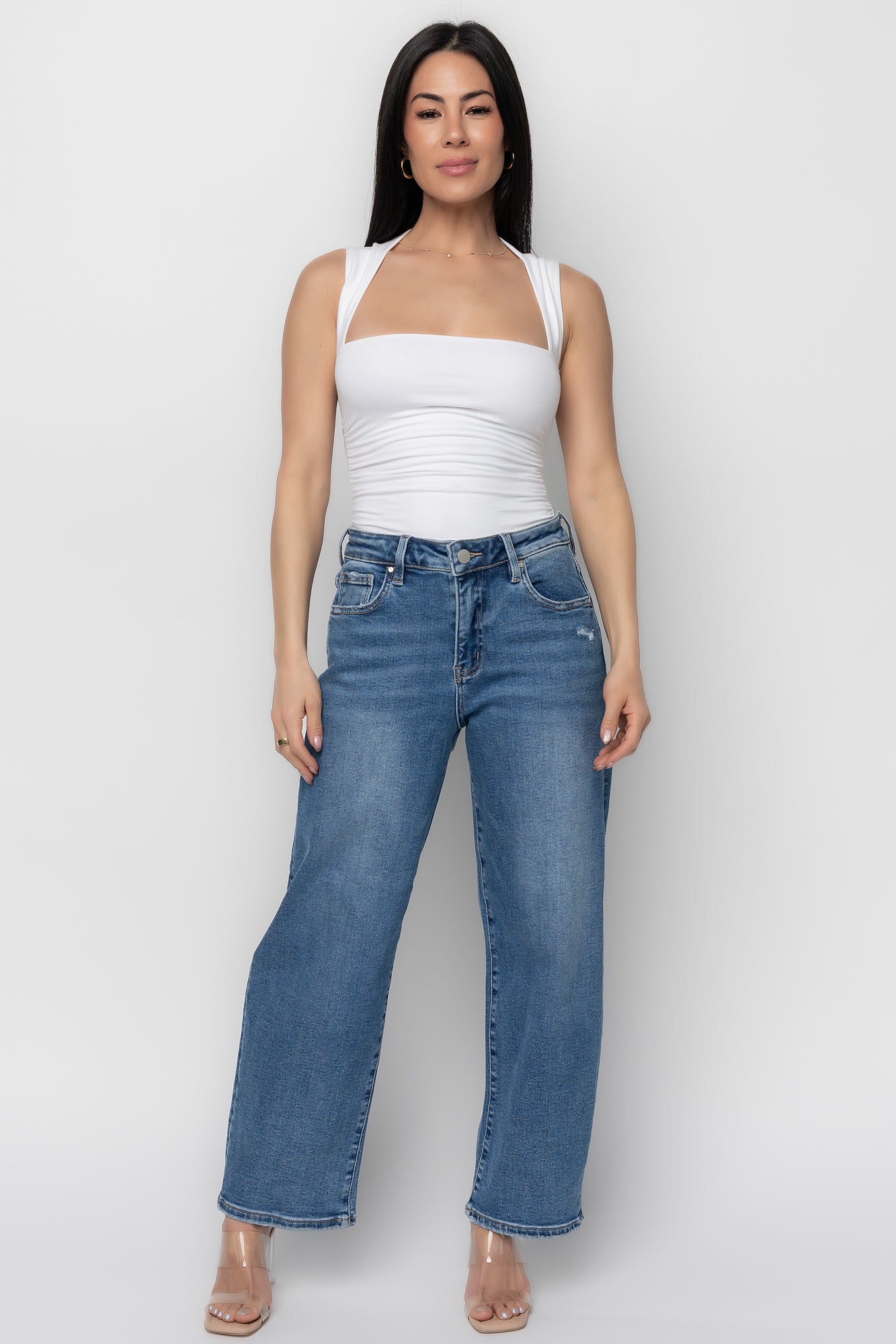 Lifestyle shot of Lumi medium-wash jeans in motion on model, demonstrating the stretch blend, relaxed barrel leg, and casual distressed accents.