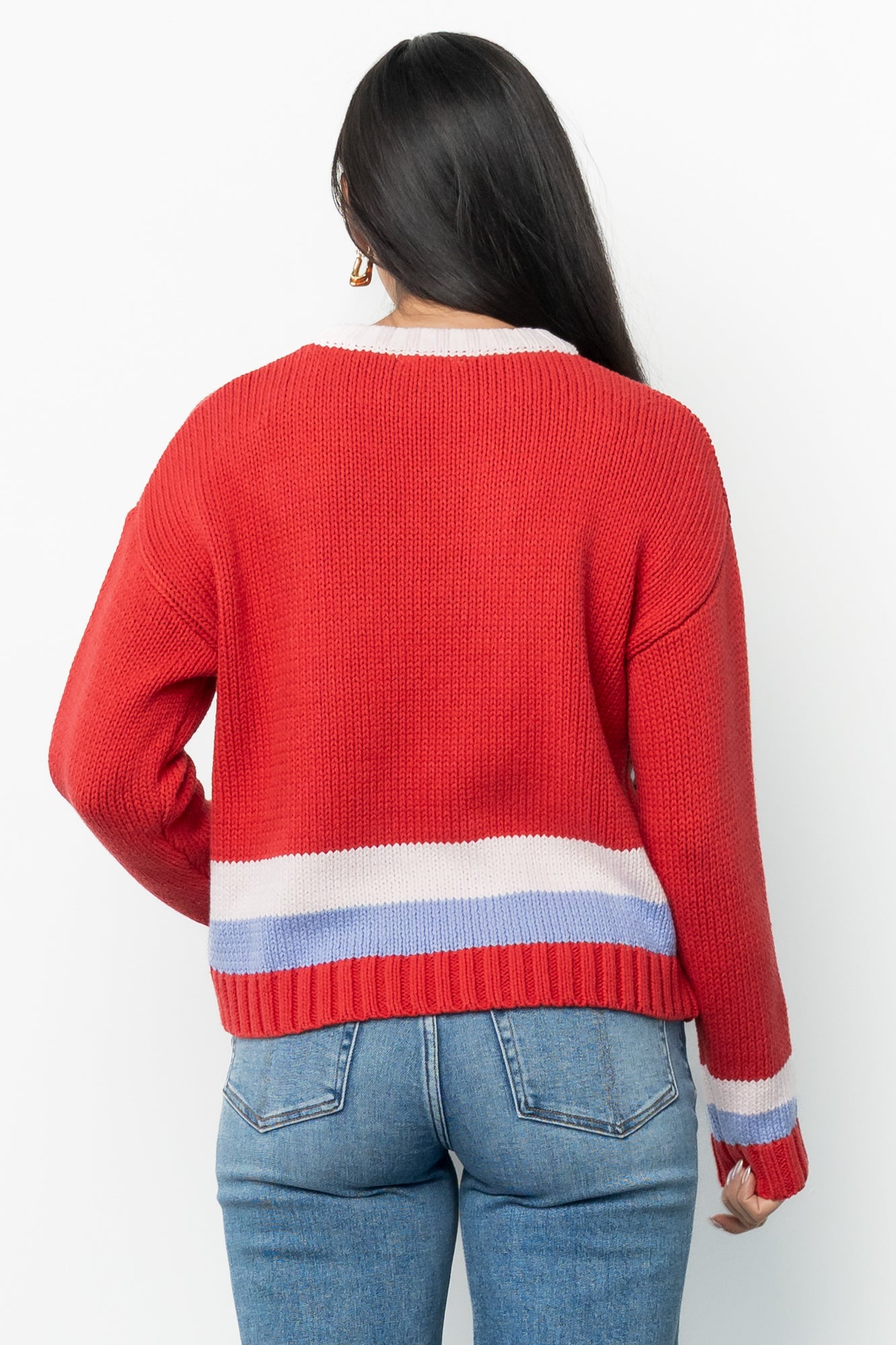 Styled flat-lay of the red multi Gilli ski sweater paired conceptually with high-rise straight-leg jeans to demonstrate an outfit idea.
