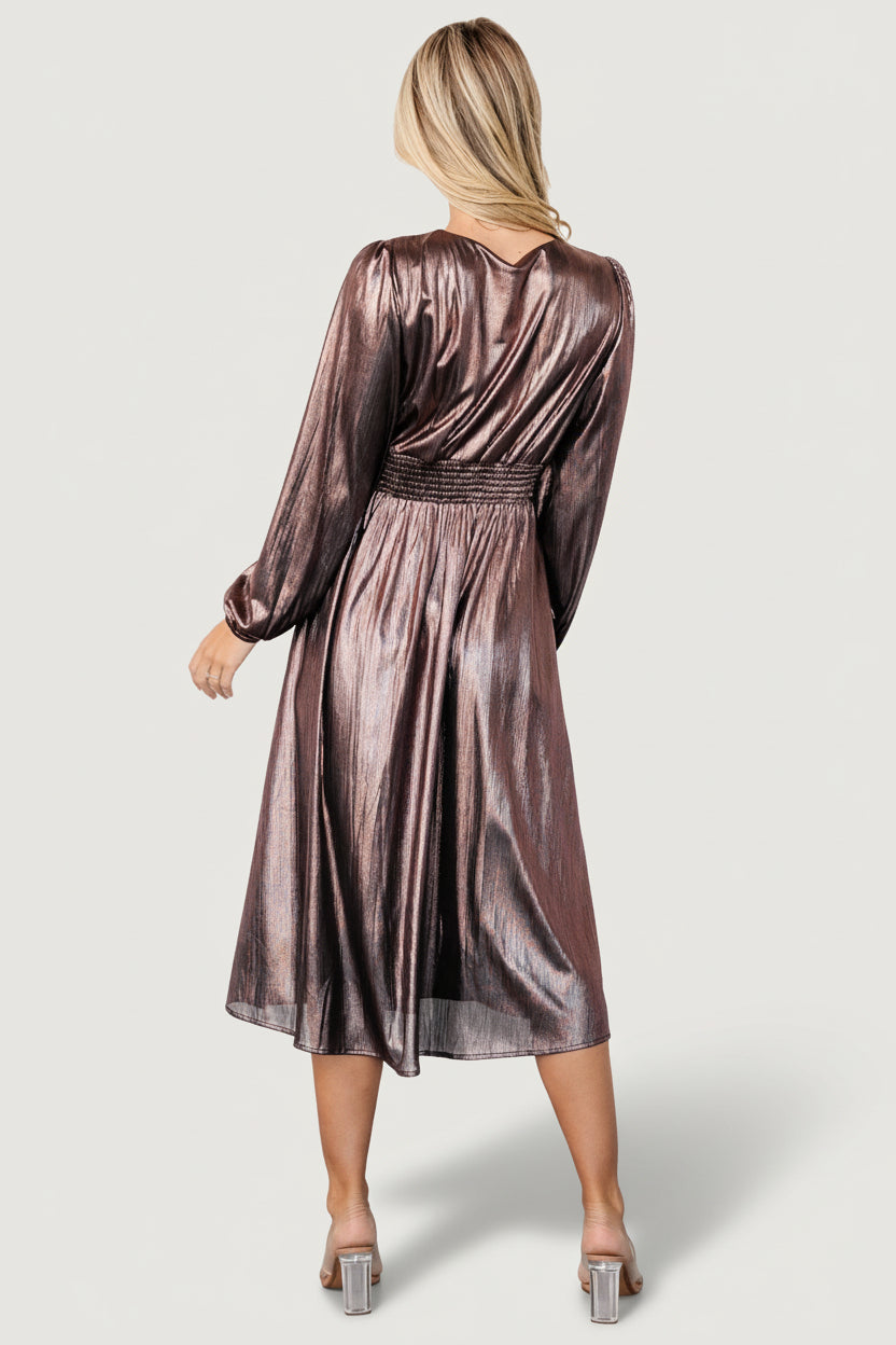 Movement shot showing the gathered, flowing skirt and midi length in bronze shimmer fabric with subtle sheen.