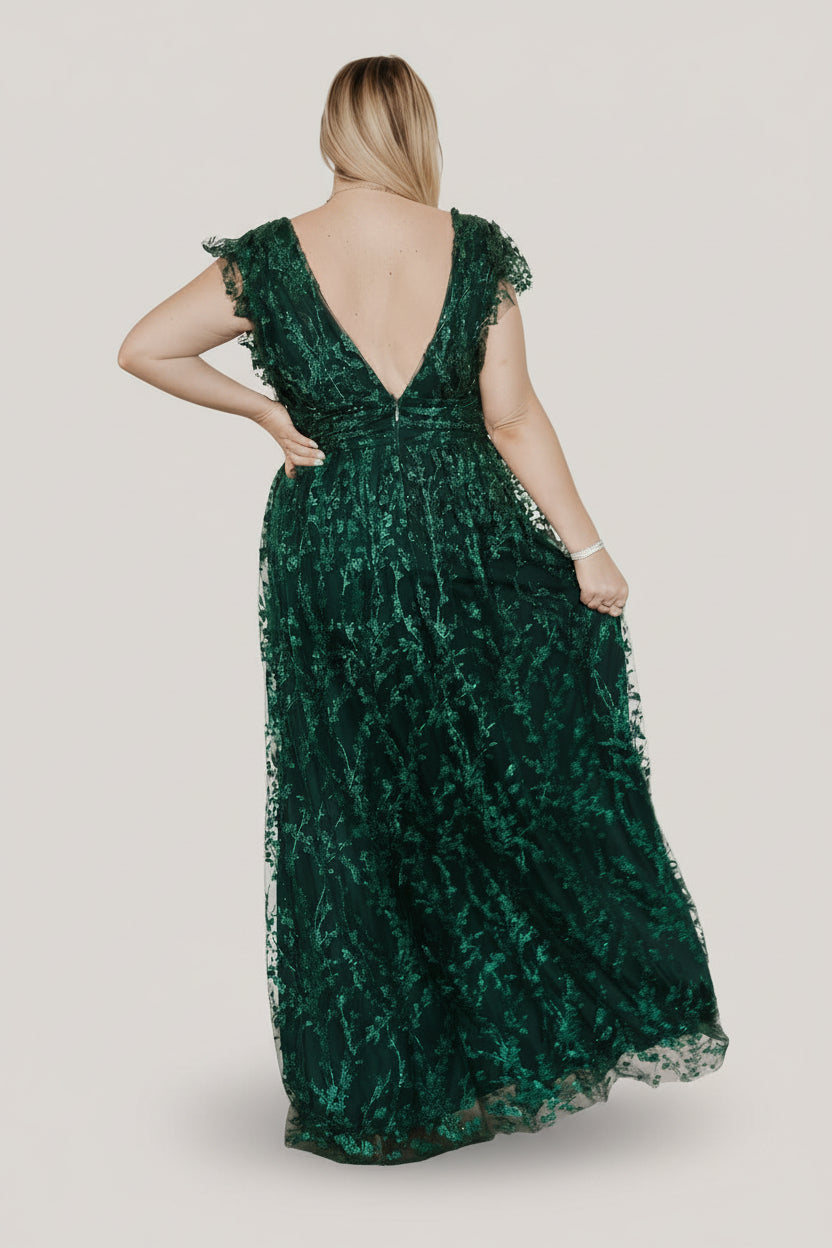 Styled image of the Arlene Shimmer Gown in emerald, highlighting sleeve tulle frills, banded waist, and flowing maxi skirt with glittered accents.