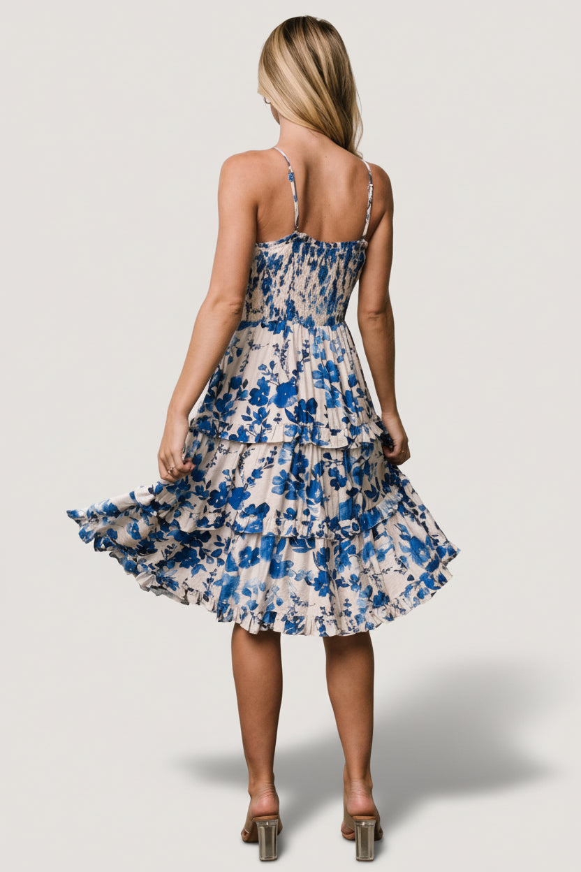 Side view showing functional side pocket and elastic waist of the Calina tiered midi dress in ivory and blue floral.