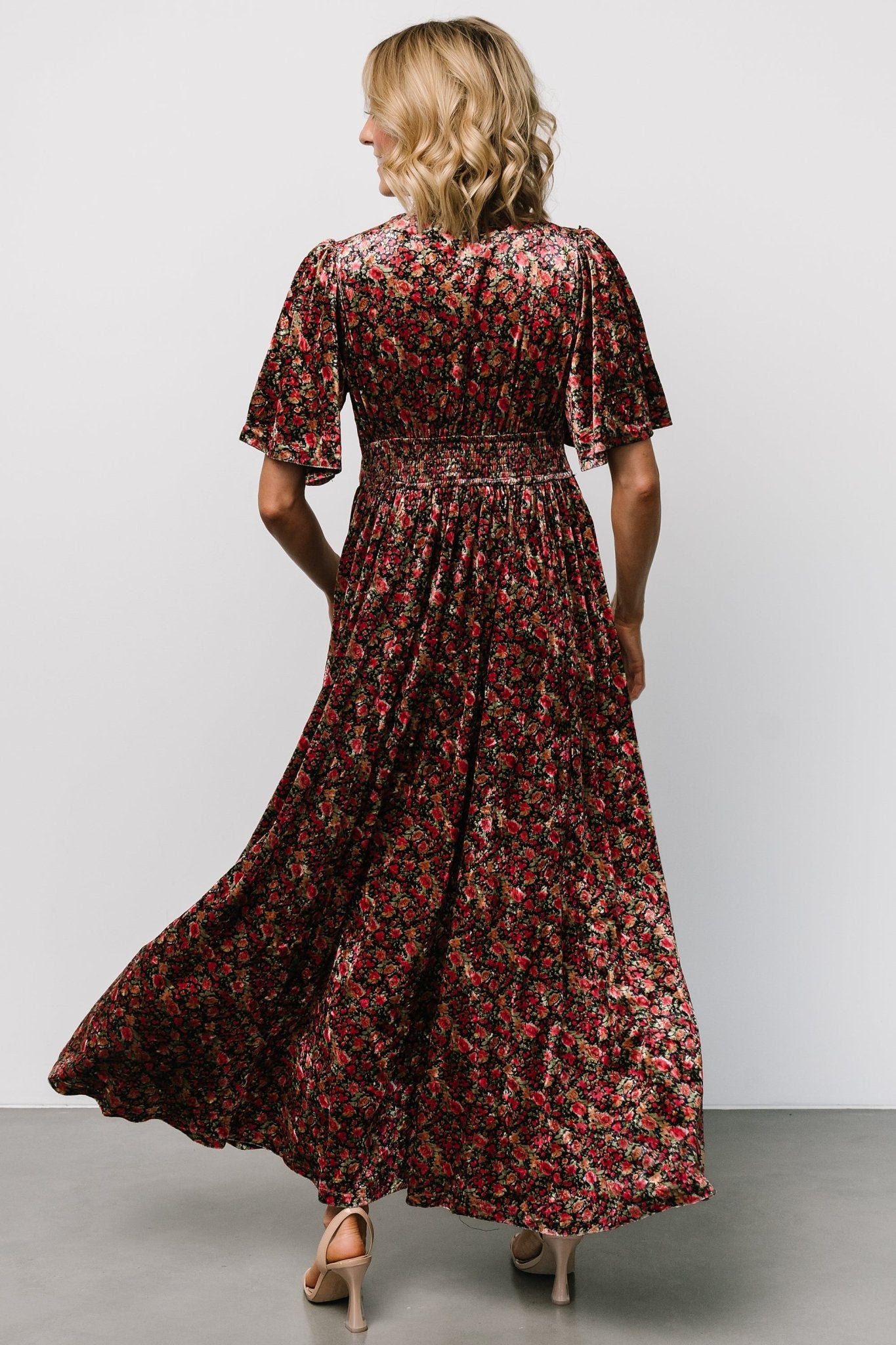Back view of the Irina Velvet Maxi Dress in black multi floral showing smocking at the back waist and the flowing maxi skirt.