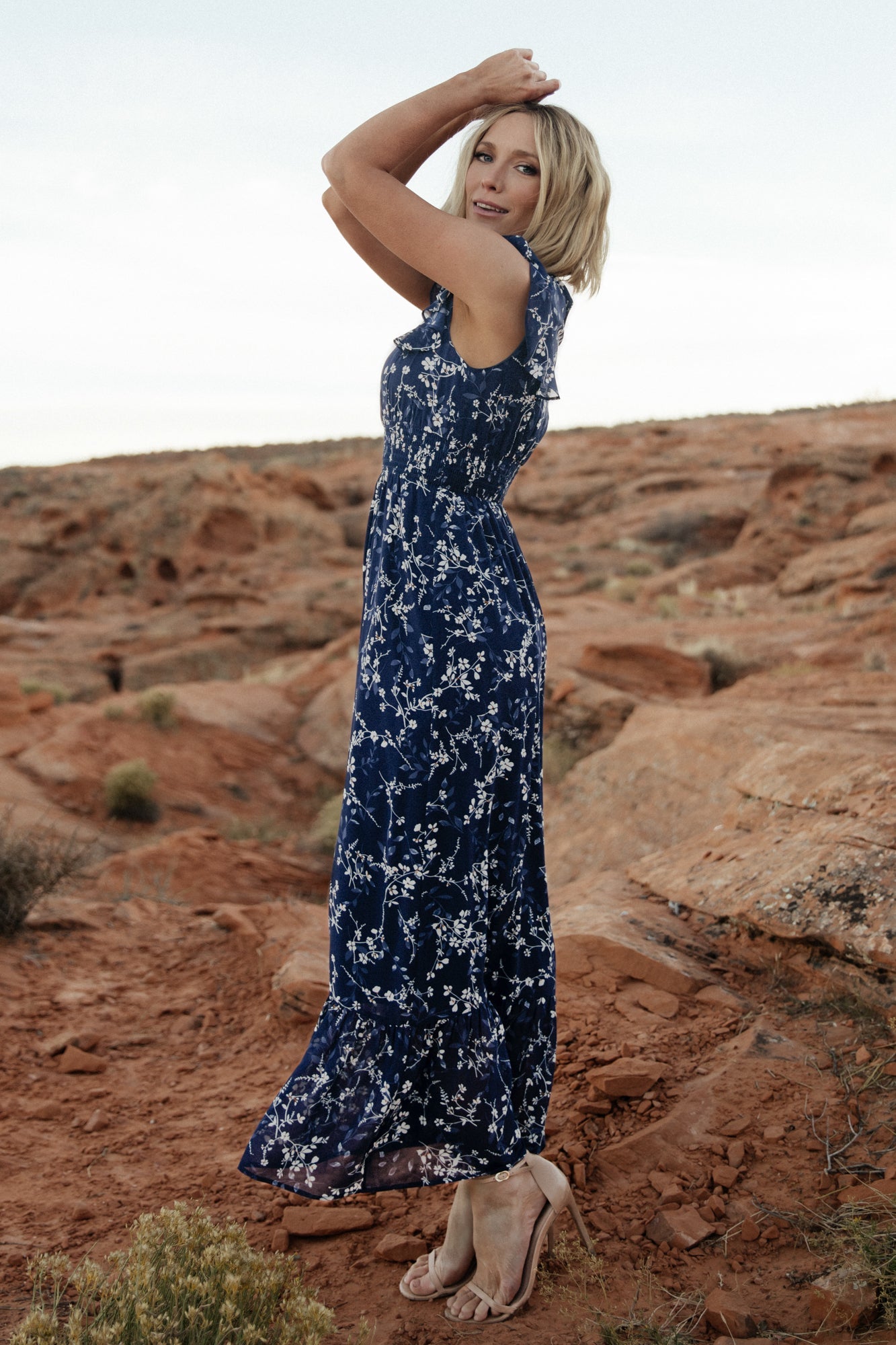 Detail shot of short flutter sleeve and ruffle trim on the blue floral chiffon dress, capturing fabric movement and pattern.