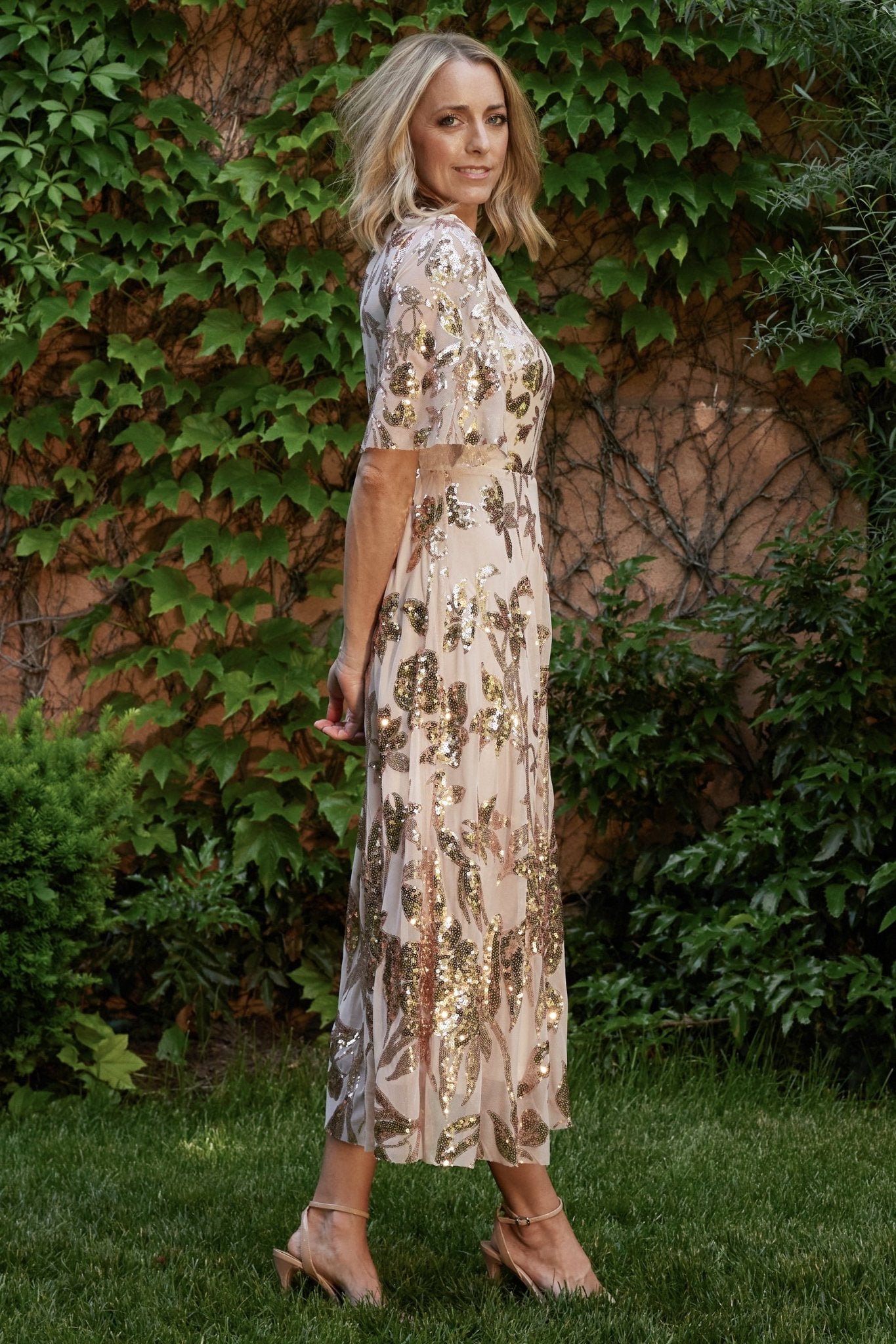 Back view highlighting the keyhole and button closure with gathered elastic waistband and flowing maxi skirt of the dress.