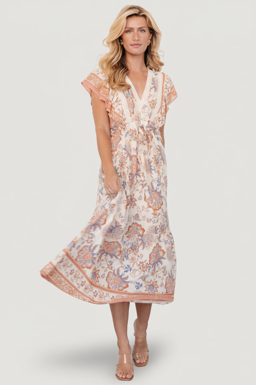 Tiered maxi skirt shown in motion, complemented by butterfly sleeves and a feminine silhouette ideal for weddings and travel.