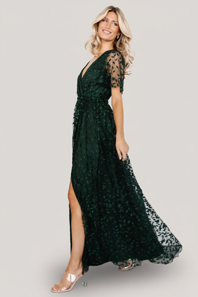 Detail image of the waist tie, elastic waistband, and fabric texture on the dark green vine-embossed maxi dress emphasizing adjustable shaping.