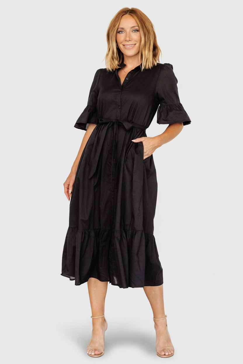 Styled look of the Mirielle black midi dress paired with neutral shoes to show versatility for day-to-night dressing.