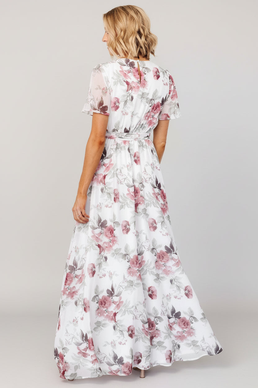 Model walking in Naomi maxi dress, showing the skirt's sweeping movement, left leg slit, and feminine silhouette.