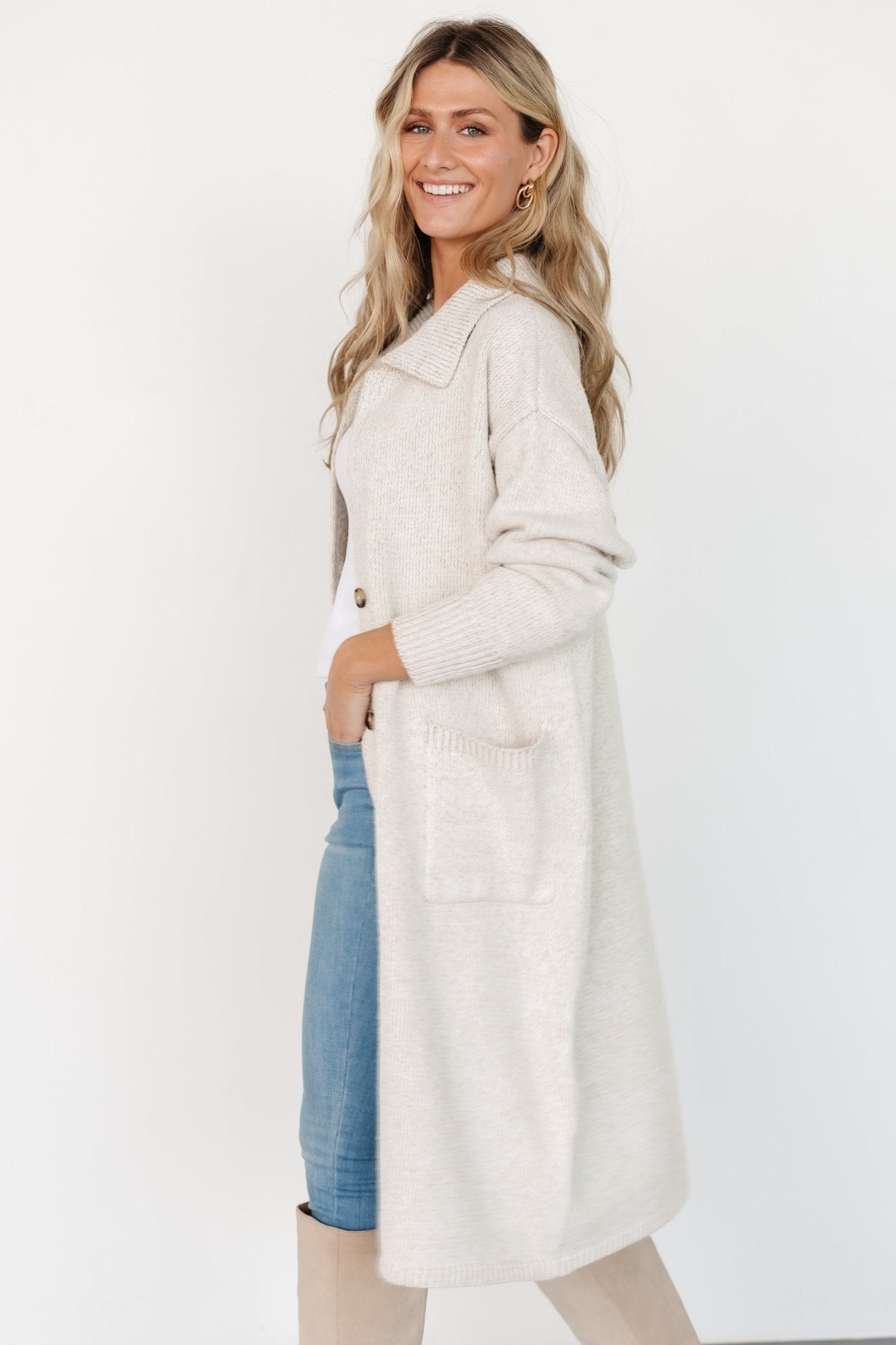 Back view of oatmeal cardigan on model, highlighting longline hem and relaxed open fit with subtle ribbed structure.