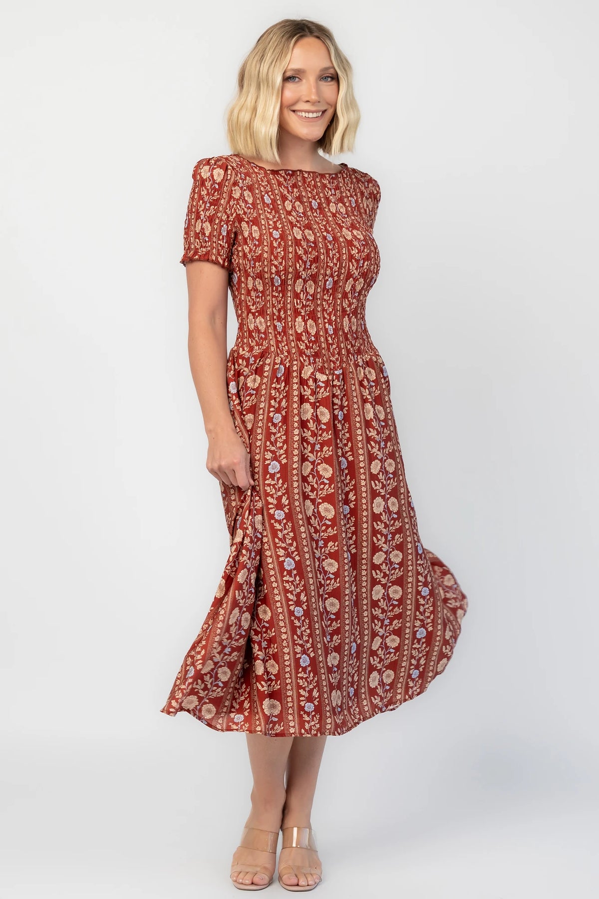 Rhonda Smocked Midi Dress in Rust Print with a round neckline, smocked bodice, and ruffled sleeve edges.