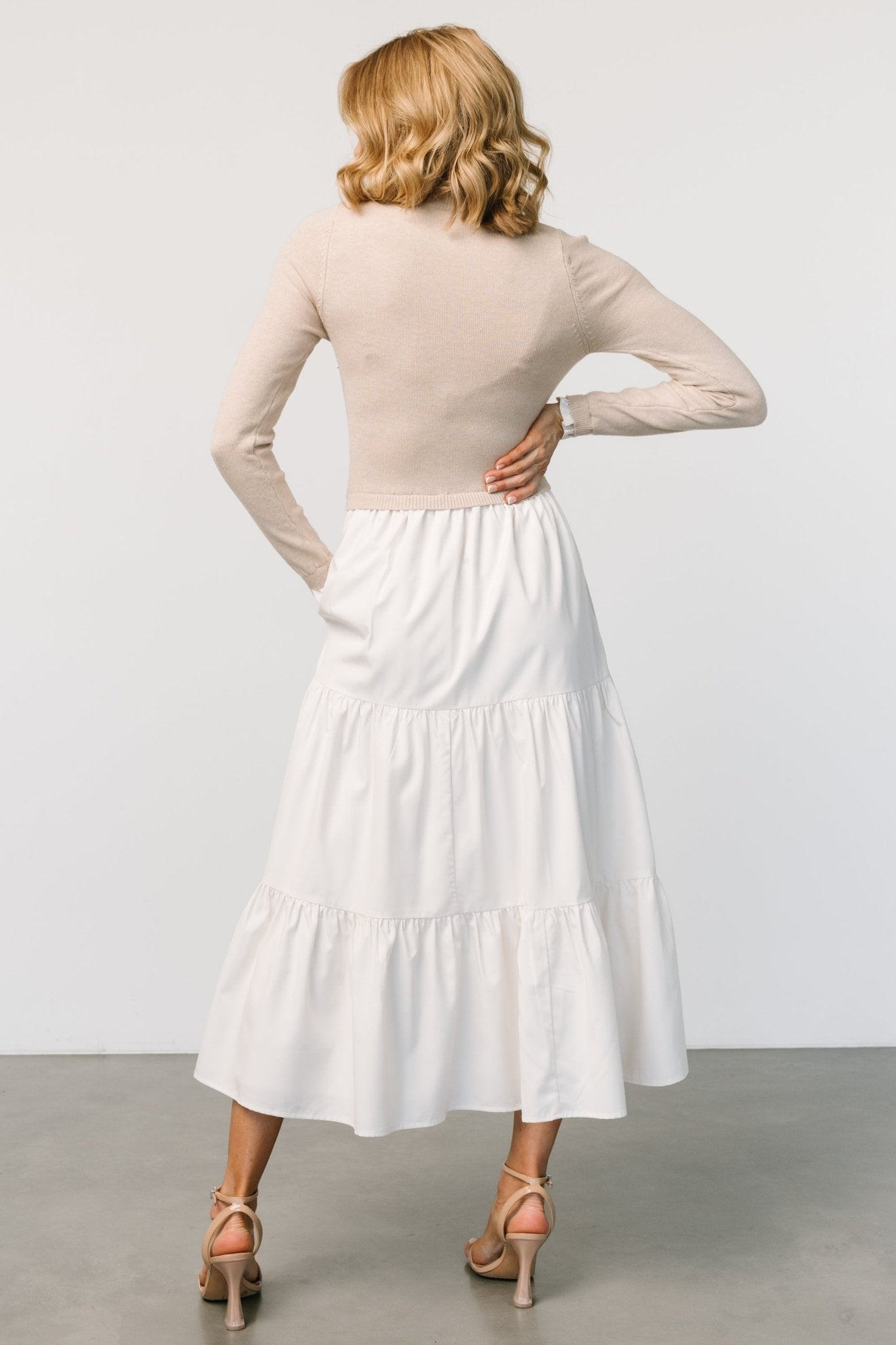 Back view of Sophie Sweater Dress in Natural showing seam lines and tiered skirt construction.