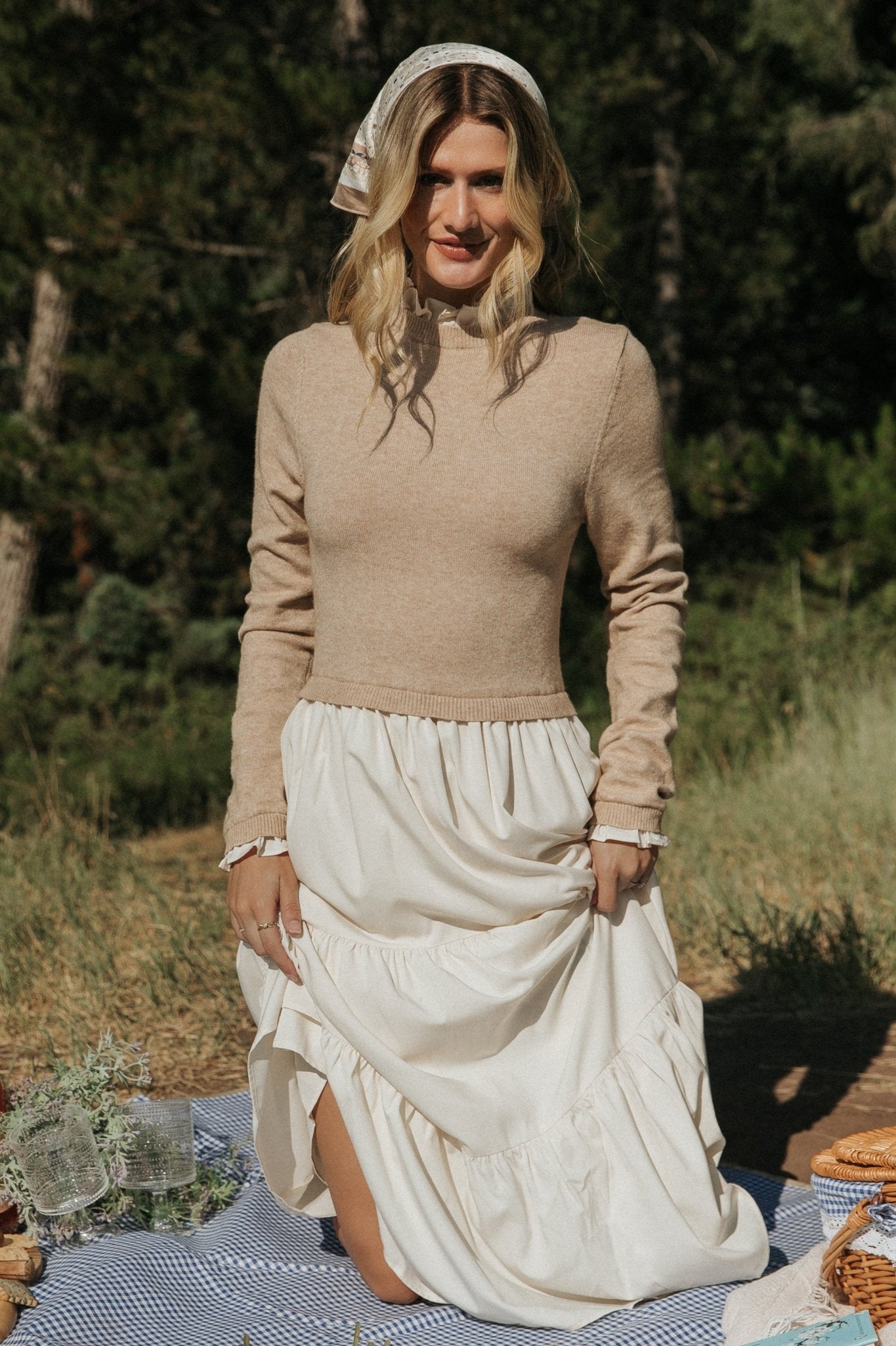 Lifestyle image of Sophie Sweater Dress in Natural styled for daytime — boots and coat pairing suggestion visible.