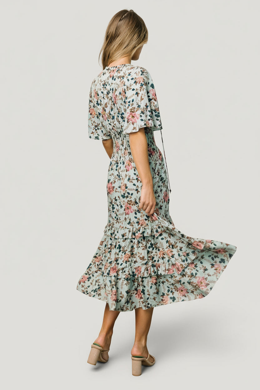 Lifestyle image of the sage and pink floral Spell Boho Midi Dress styled for daytime occasions, showing print and silhouette.