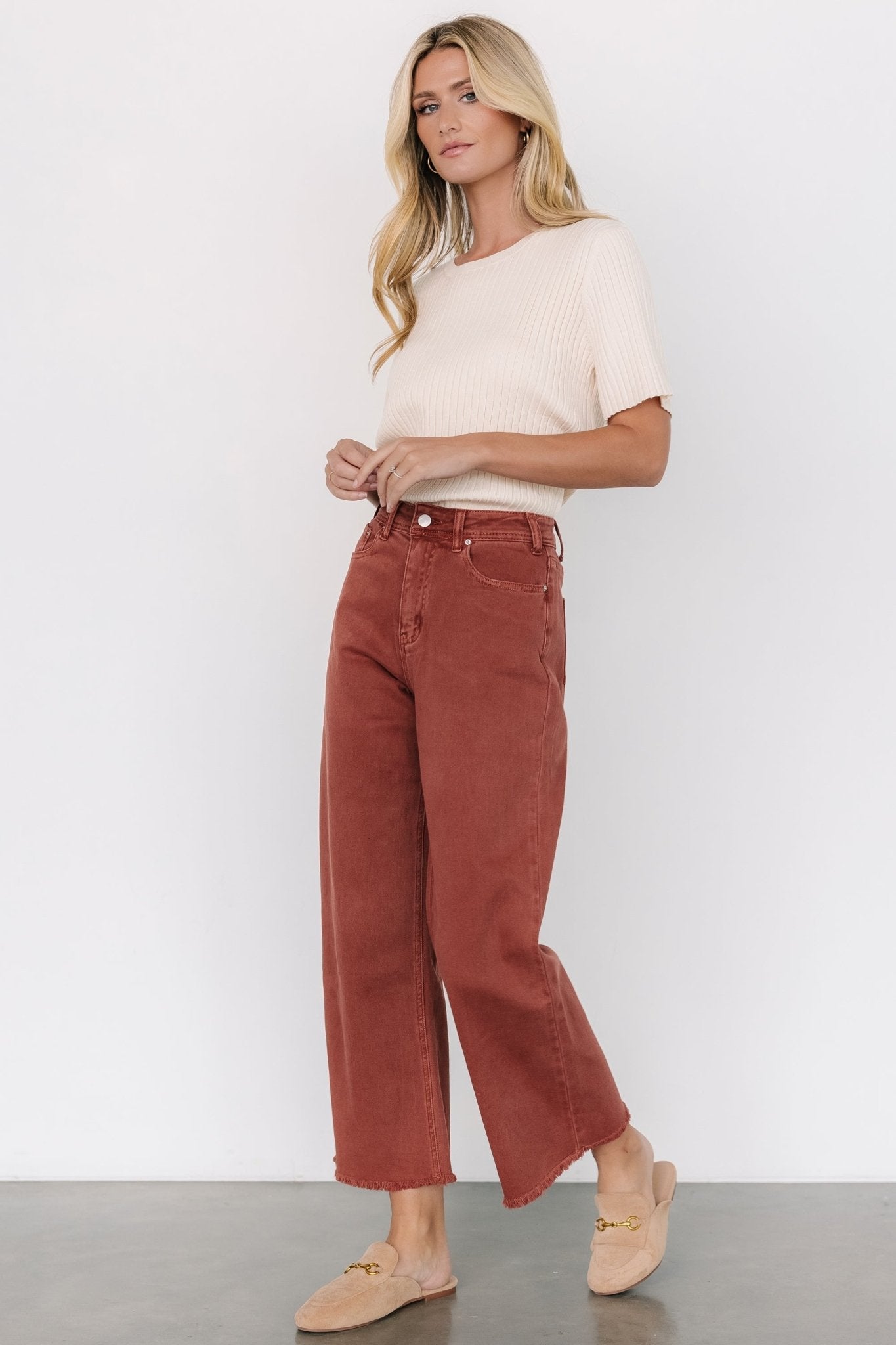 Lifestyle shot of Spence terracotta denim pants styled for a seasonal outfit, emphasizing color, cut, and wearable design details.